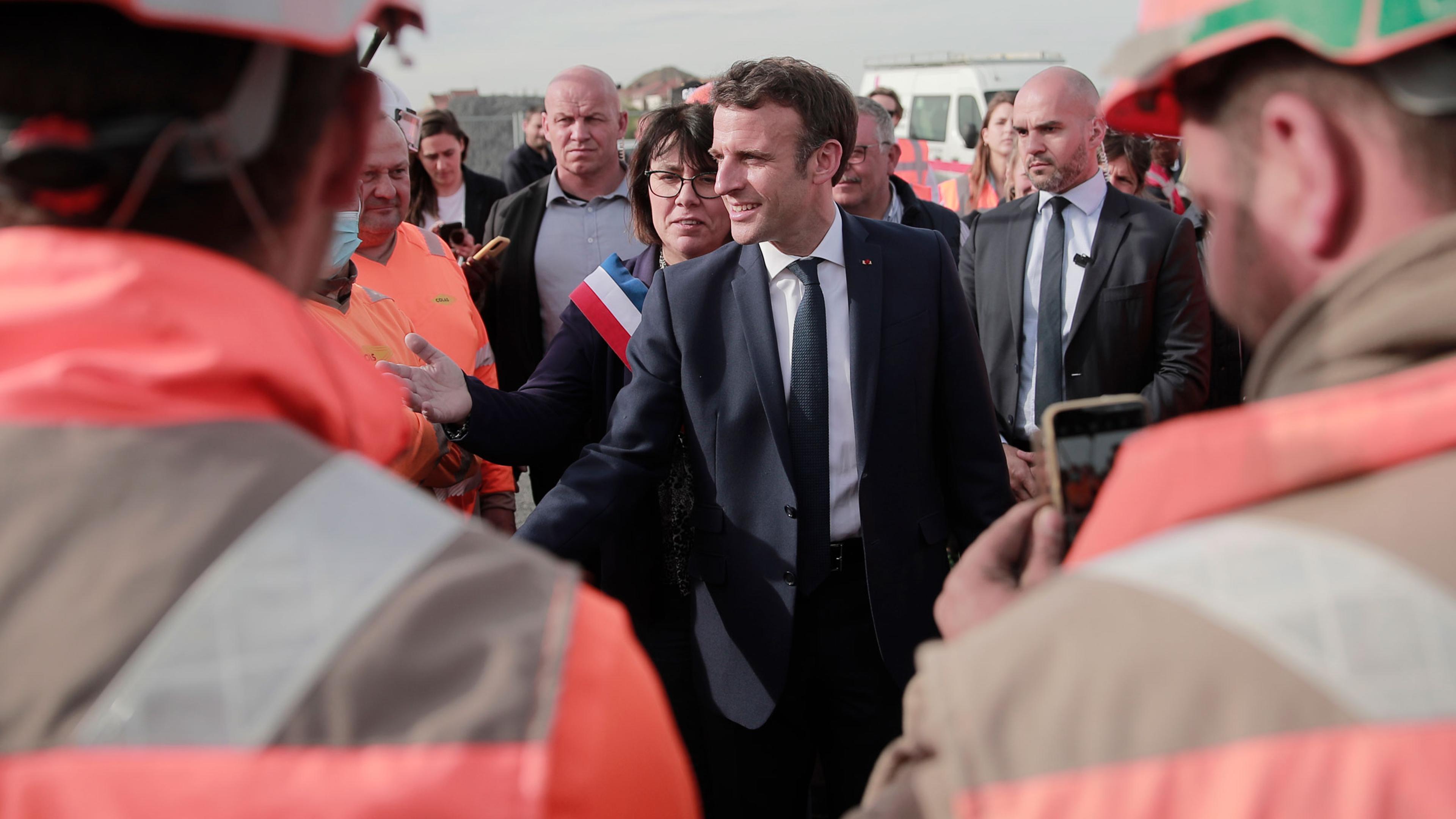 Emmanuel Macron and local mayor Anne-Lise Dufour-Tonini meet workers as he visits a building site