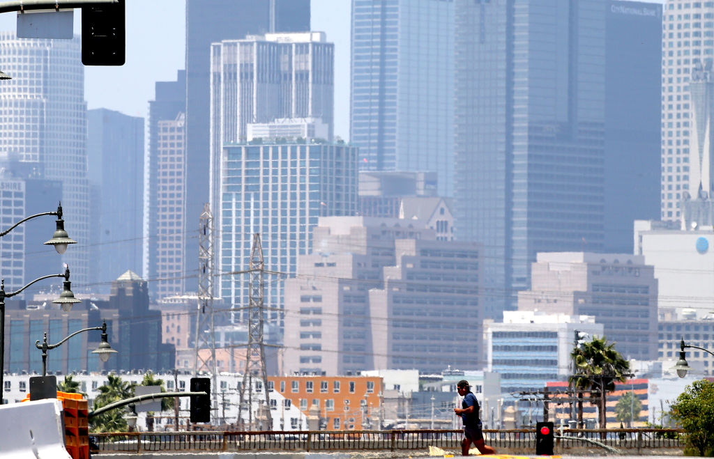 A jogger is dwarfed by the downtown Los Angeles skyline on July 6, 2023. A heatwave is forecast for Los Angeles and Southern California.