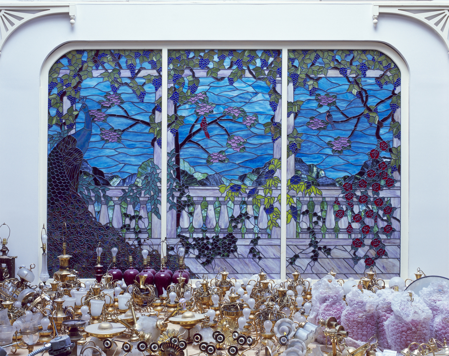 Light fixtures that were part of Heritage USA are piled up near a stained-glass window during renovations to the building.