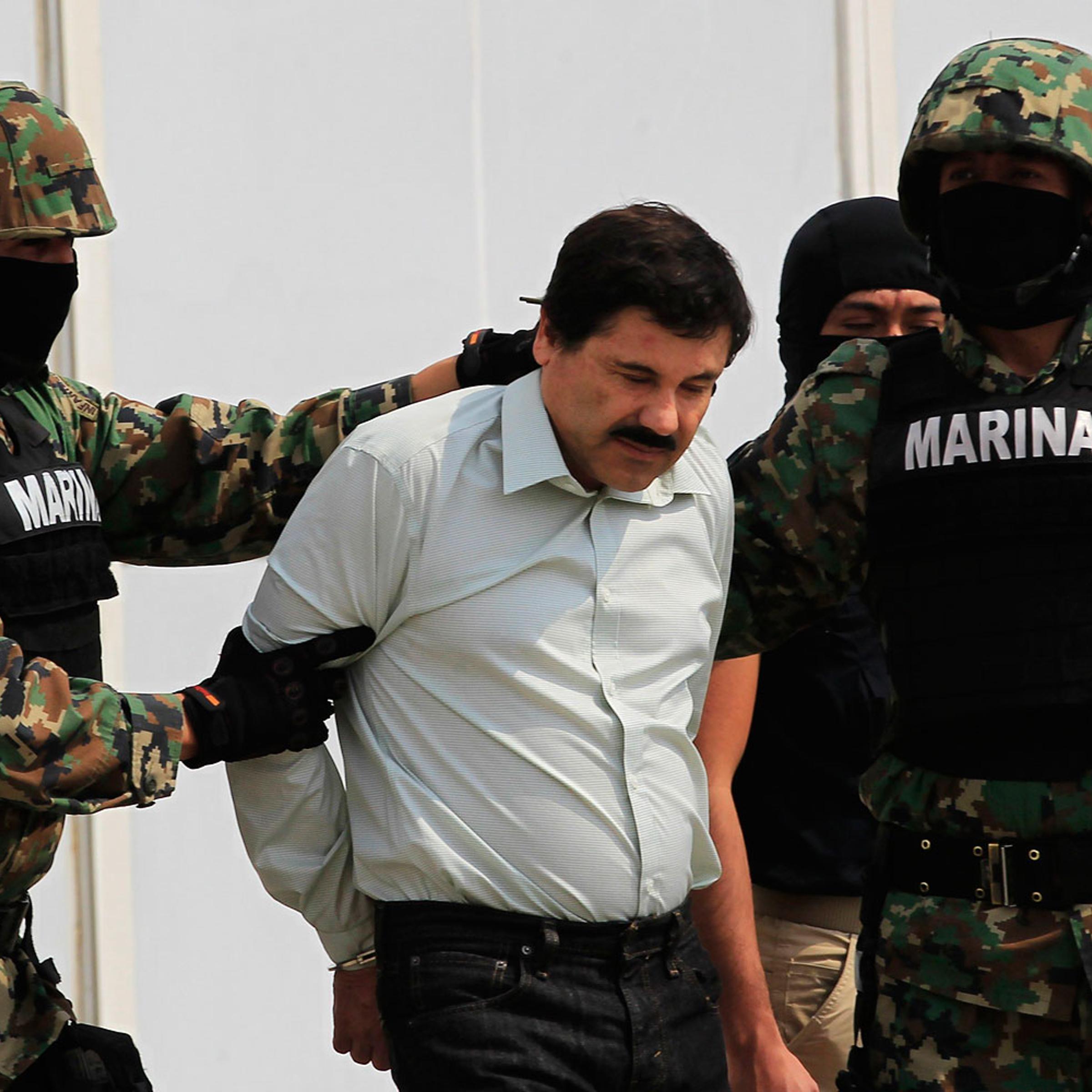 Joaquin "Shorty" Guzman is escorted by soldiers during a presentation at the Navy's airstrip in Mexico City Feb. 22, 2014.