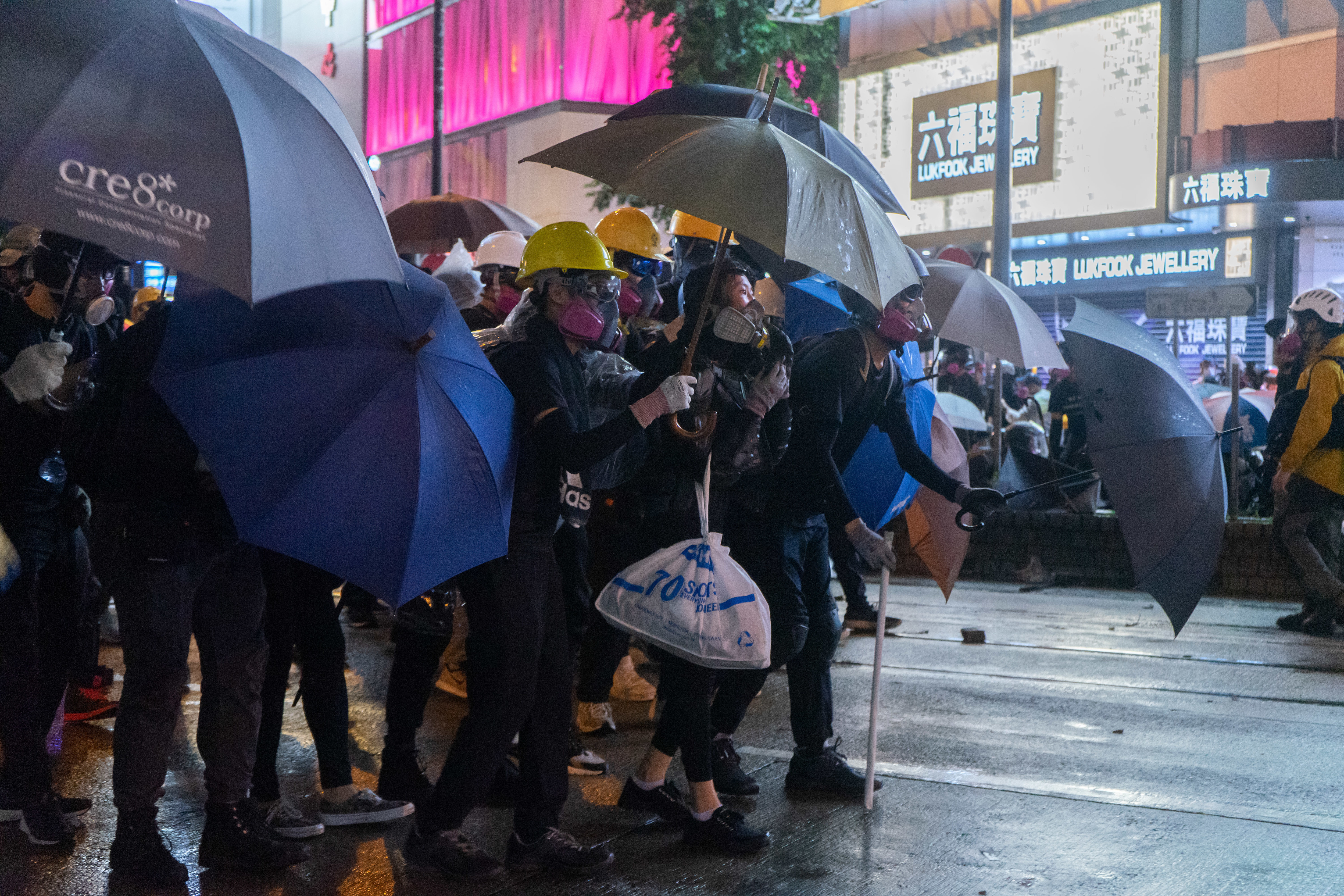 Protester hold umbrella to protect themselves from police
