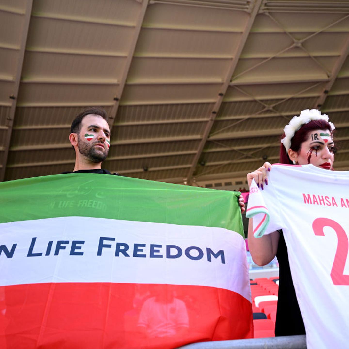 Fans hold up a shirt with the name of Mahsa Amini and a flag advocating for women's rights prior to the FIFA World Cup Qatar 2022 Group B match between Wales and IR Iran at Ahmad Bin Ali Stadium on Nov. 25, 2022 in Doha.