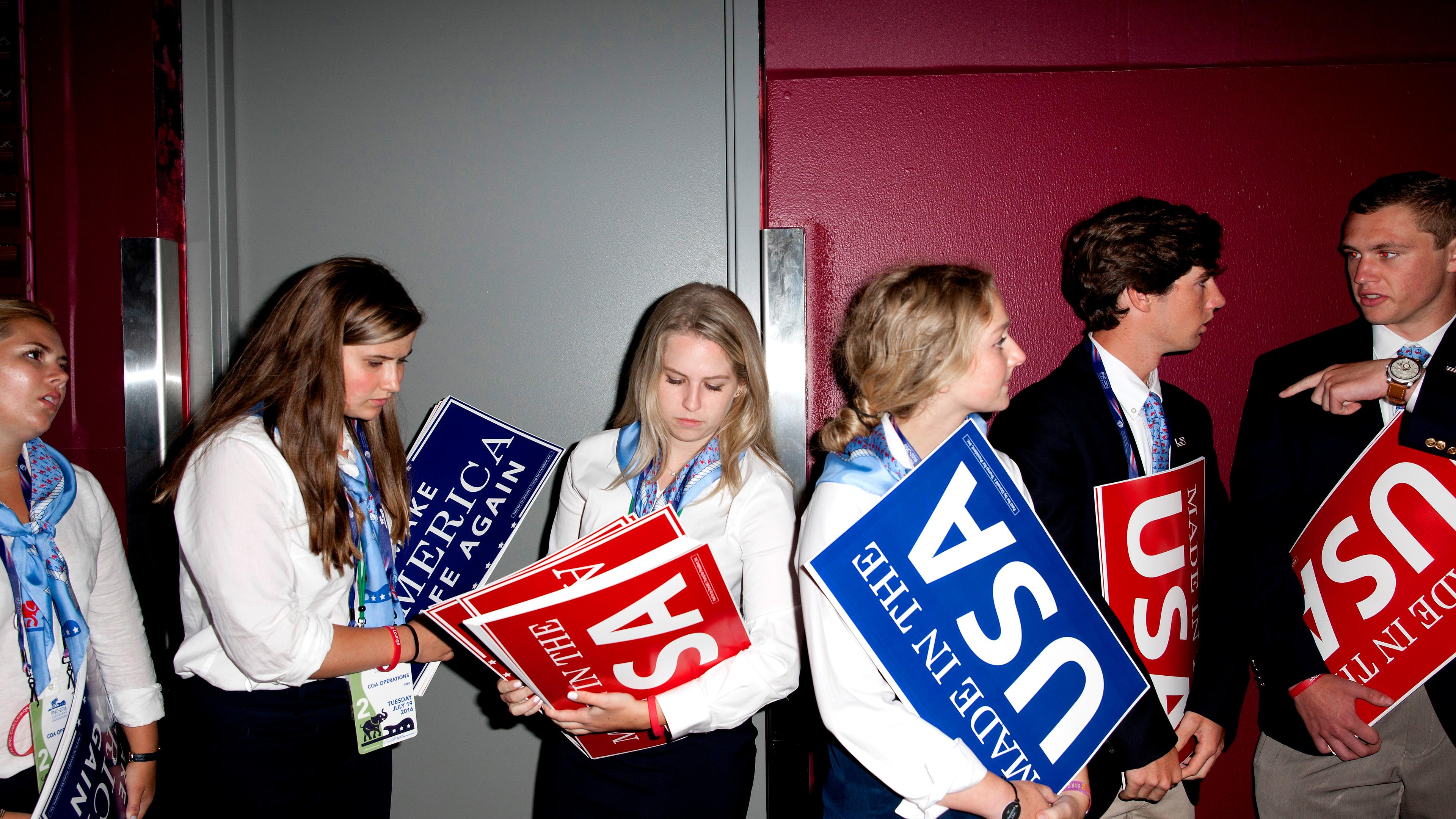 Attendees hold signs at the Republican National Convention in Cleveland on Tuesday, July 19, 2016.