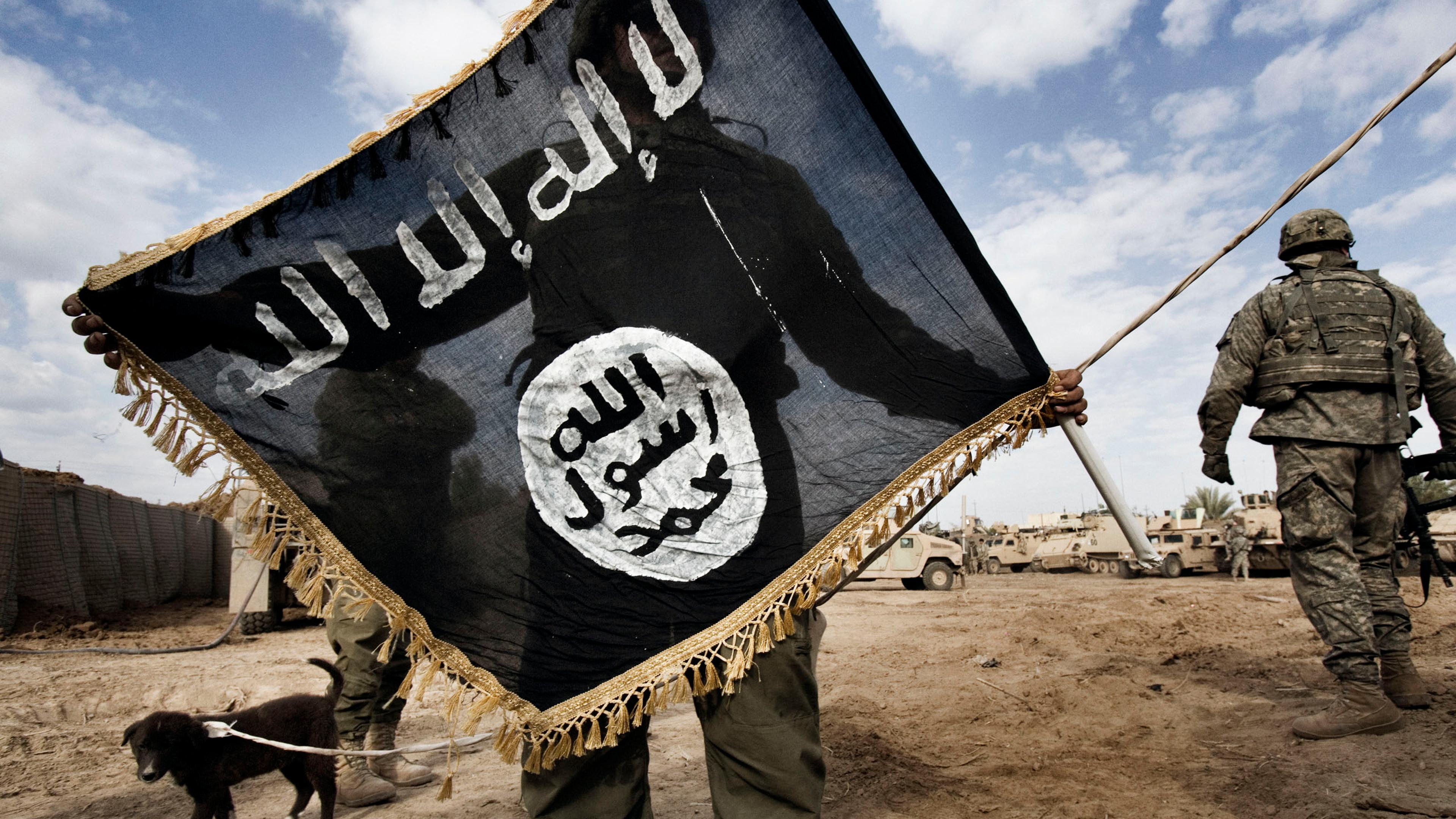 A U.S. soldier with 6th squadron, 9th cavalry of the 1st cavalry division holds the flag of al-Qaeda in Iraq (AQI) taken from the roof of a local school in Diyala province, northeast of Baghdad, which became a stronghold for the Sunni insurgency and AQI,