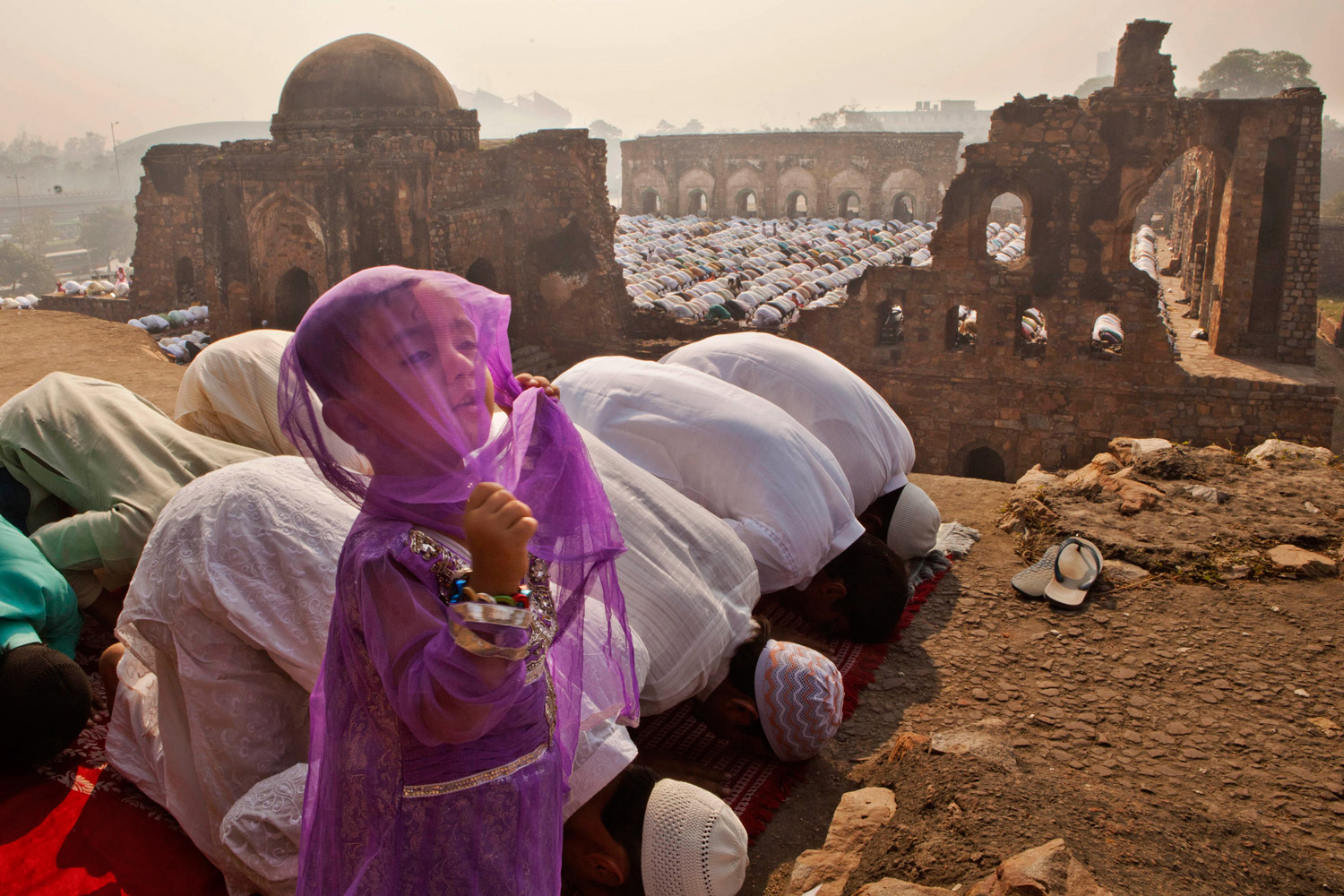 November 7, 2011. A young Indian Muslim girl stands while others pray in New Delhi during 'Id al Adha, the Festival of Sacrifice, which follows the end of the Hajj, the annual pilgrimage to Mecca. 