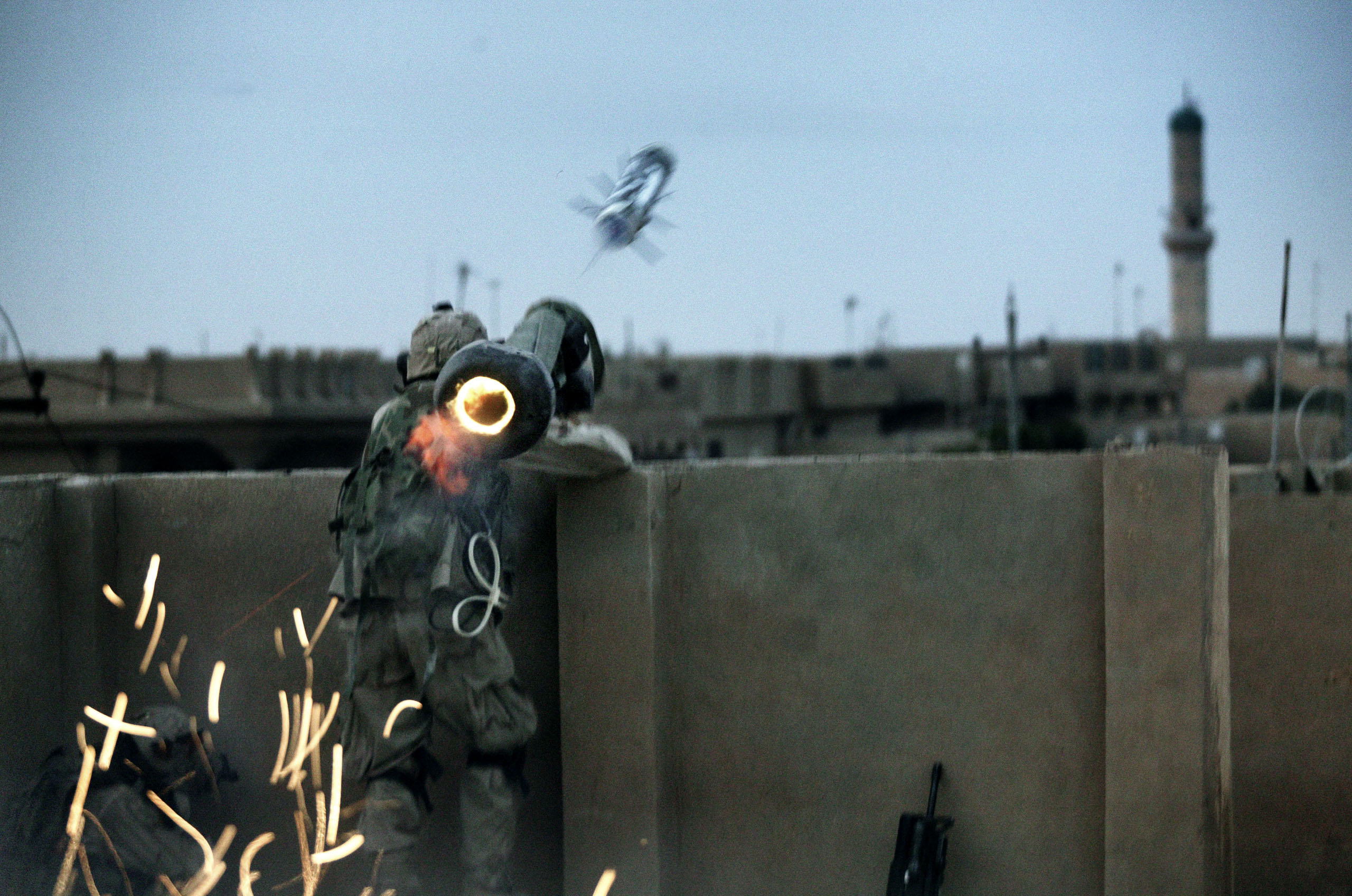 Dawn breaks in Fallujah, Iraq, as the U.S. military launched a massive offensive to retake the city from Sunni insurgents. A soldier with the Army Task Force 2-2's Alpha Company, 3rd Platoon, fires a rocket at insurgent positions from a makeshift rooftop