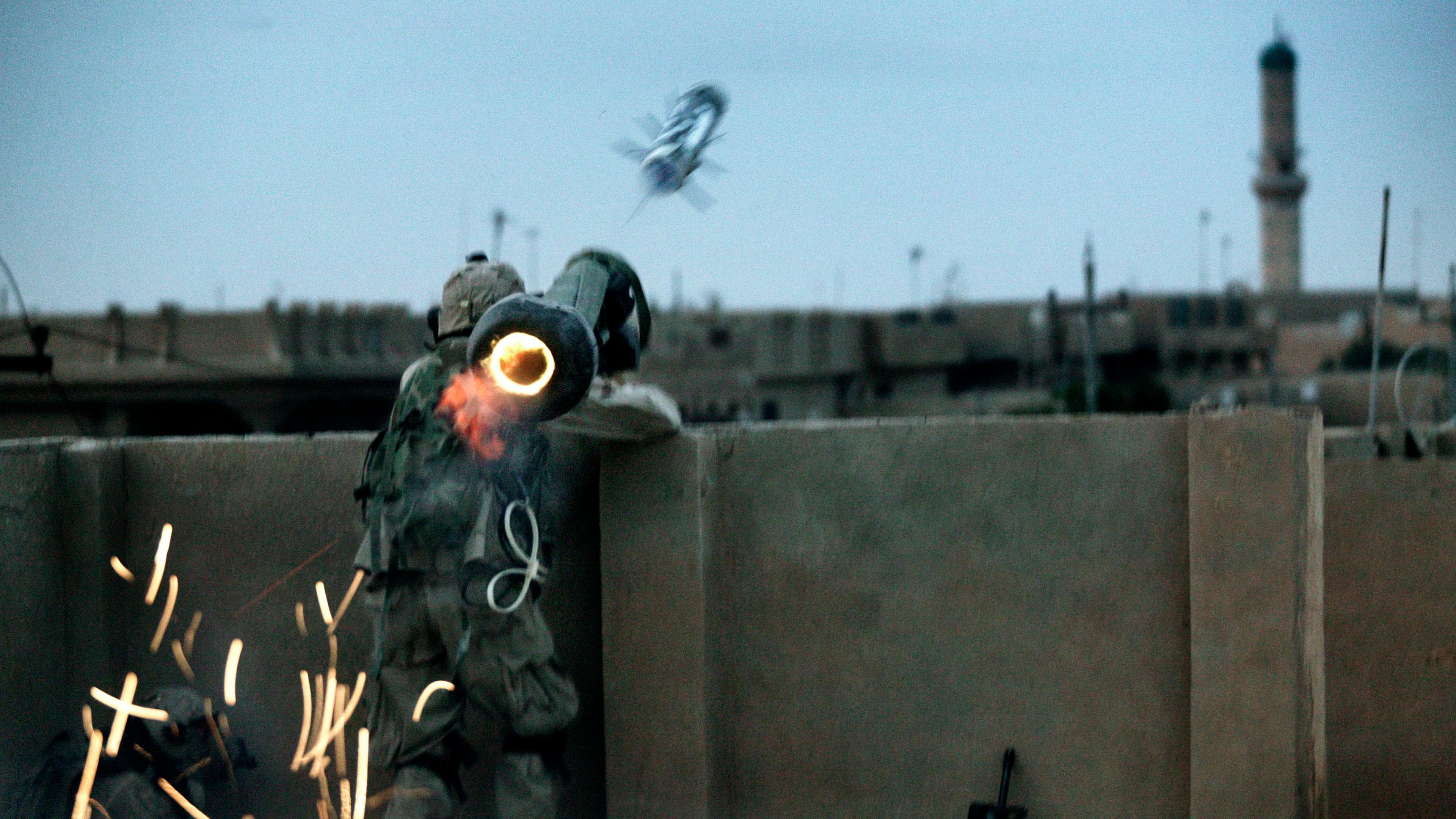 Dawn breaks in Fallujah, Iraq, as the U.S. military launched a massive offensive to retake the city from Sunni insurgents. A soldier with the Army Task Force 2-2's Alpha Company, 3rd Platoon, fires a rocket at insurgent positions from a makeshift rooftop