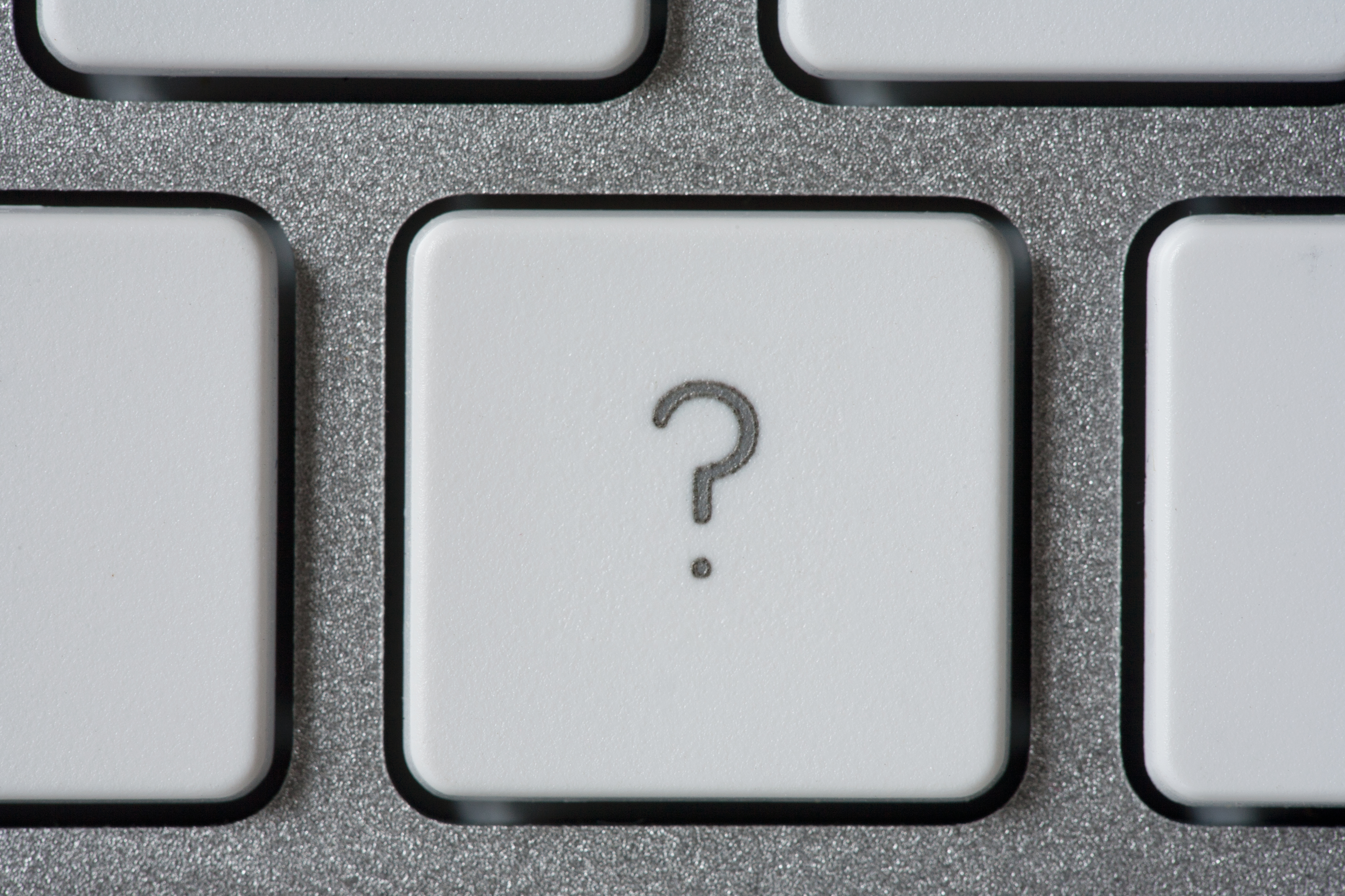 Computer keyboard with a key with a question mark.