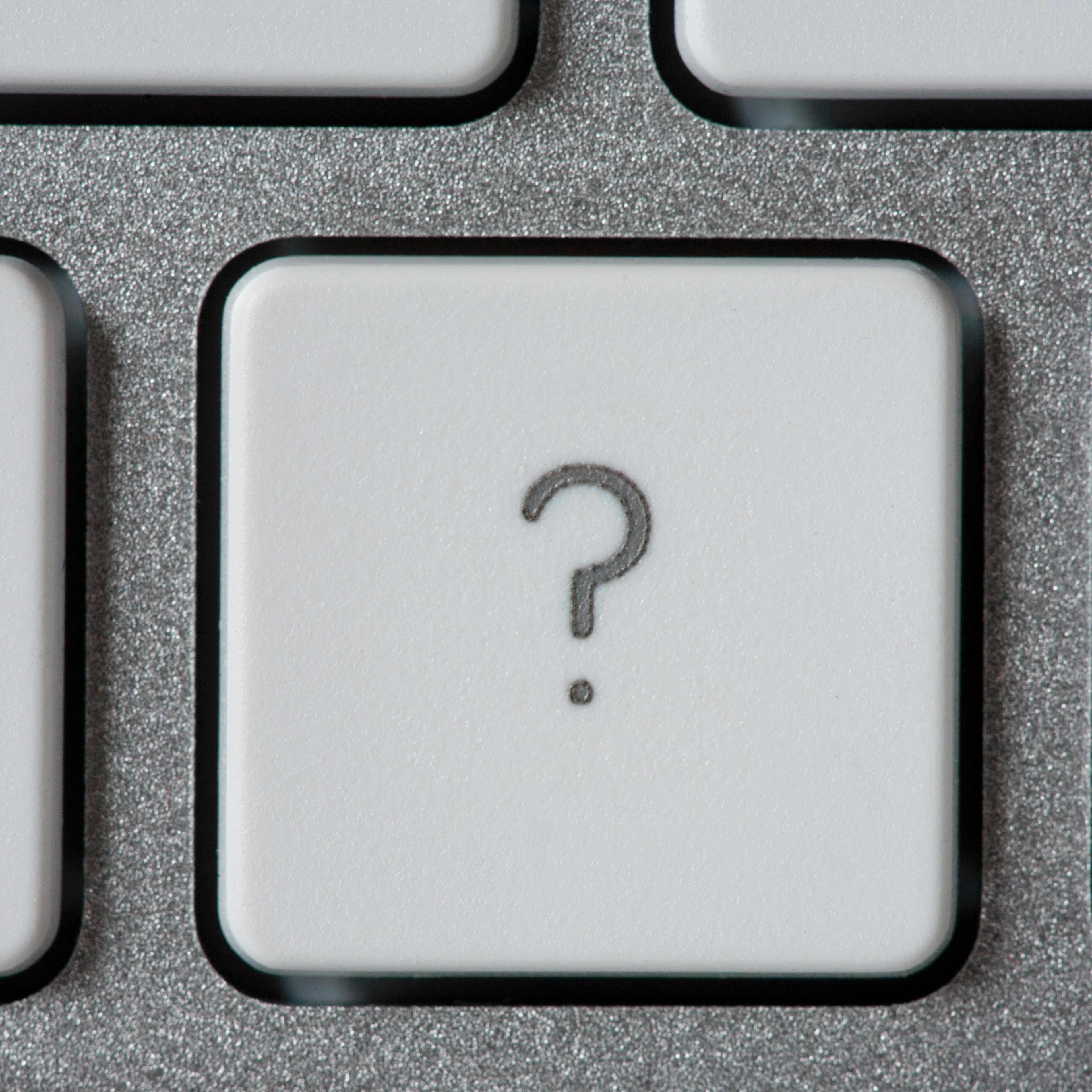Computer keyboard with a key with a question mark.