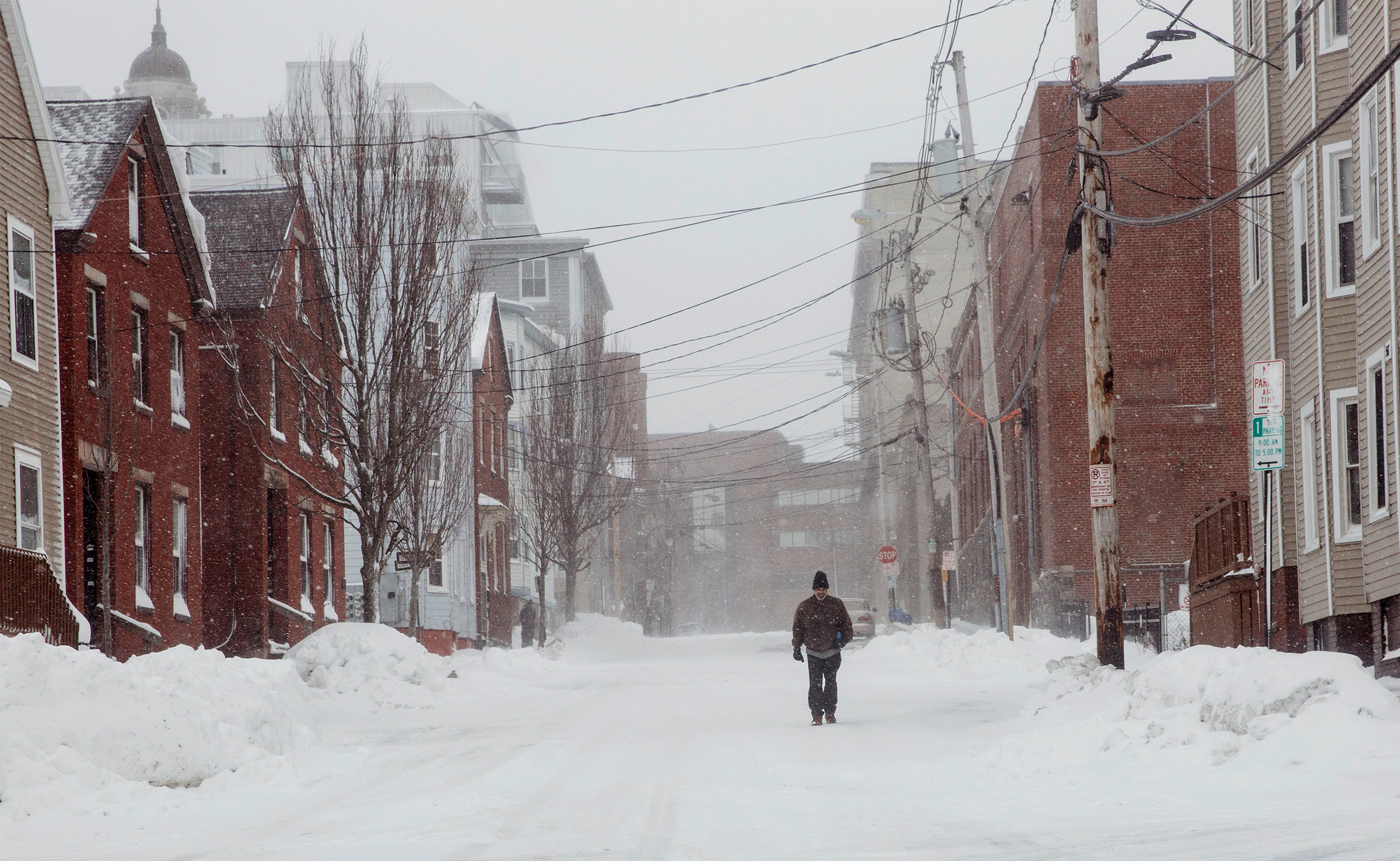 A pedestrian walks down an empty street in the Bayside neighborhood .