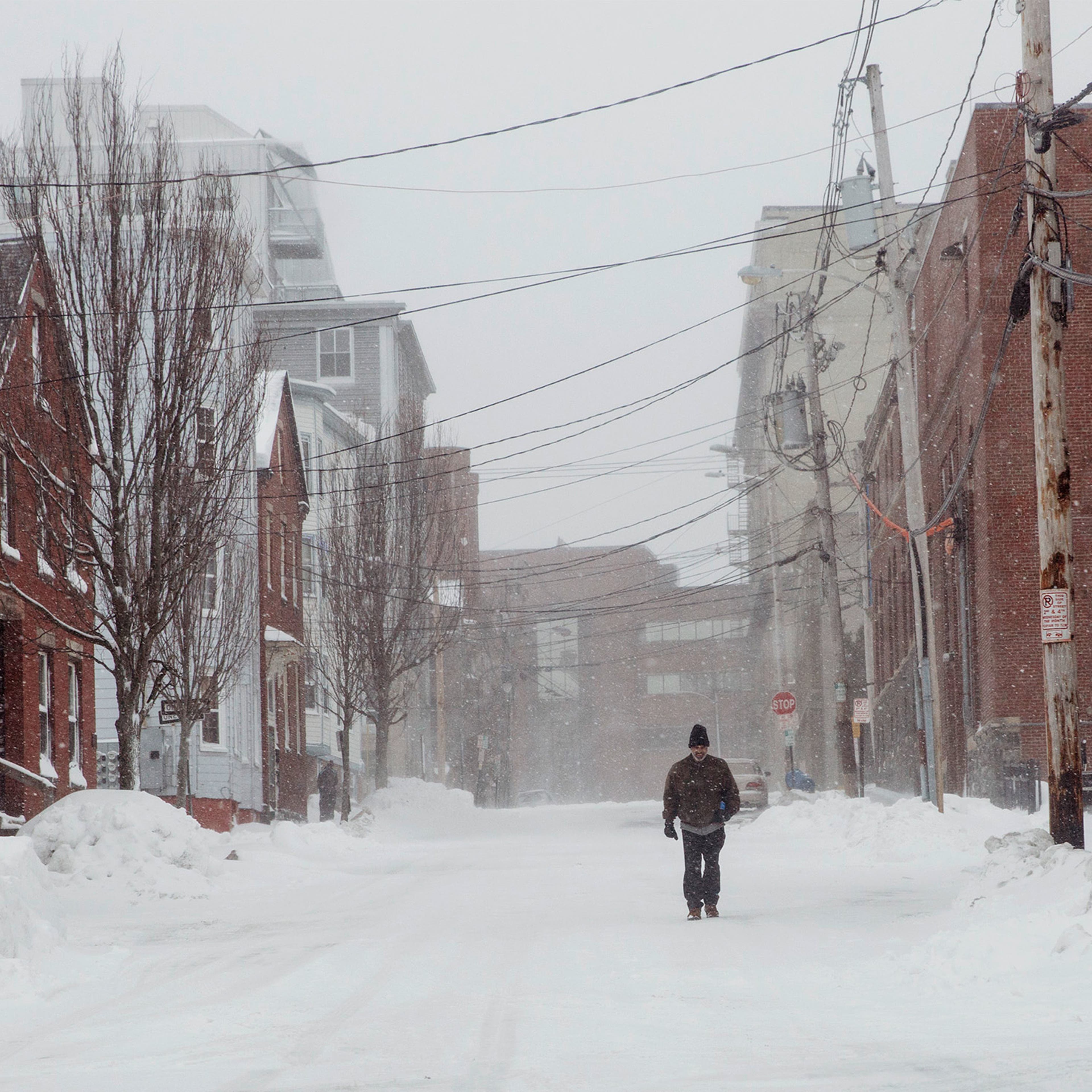 A pedestrian walks down an empty street in the Bayside neighborhood .