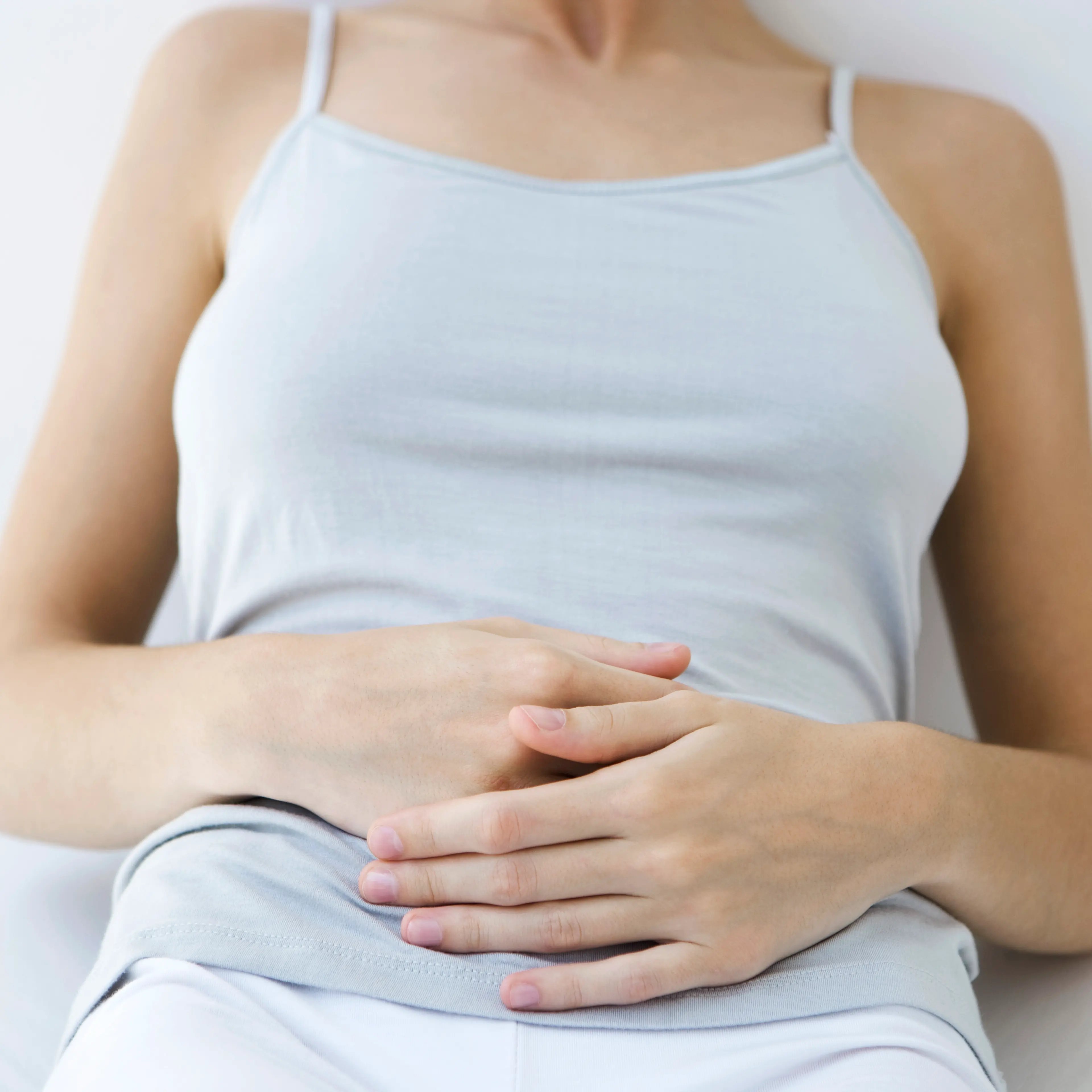 Woman holding stomach, cropped view