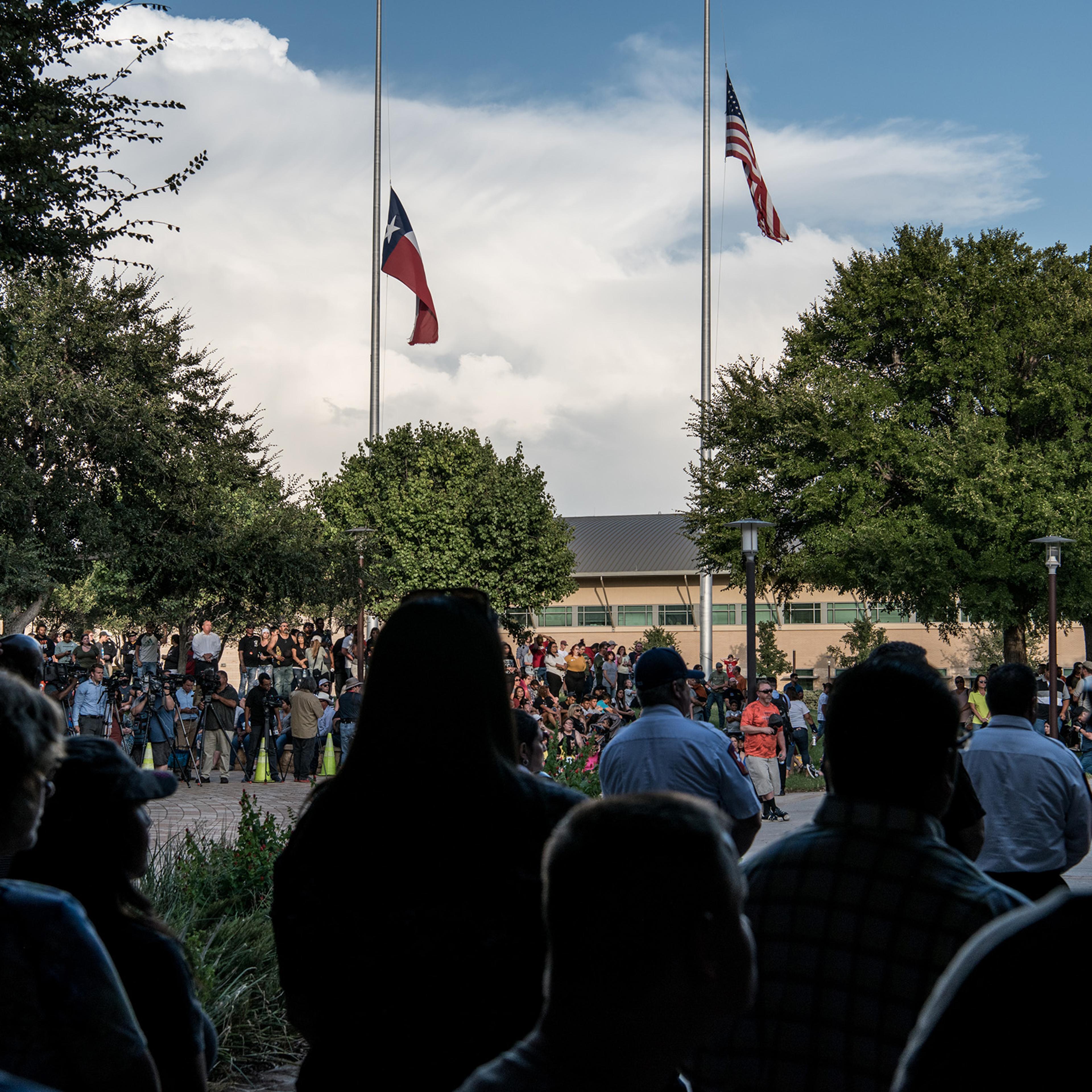 Flags fly at half mast over a prayer vigil at the University of Texas of the Permian Basin