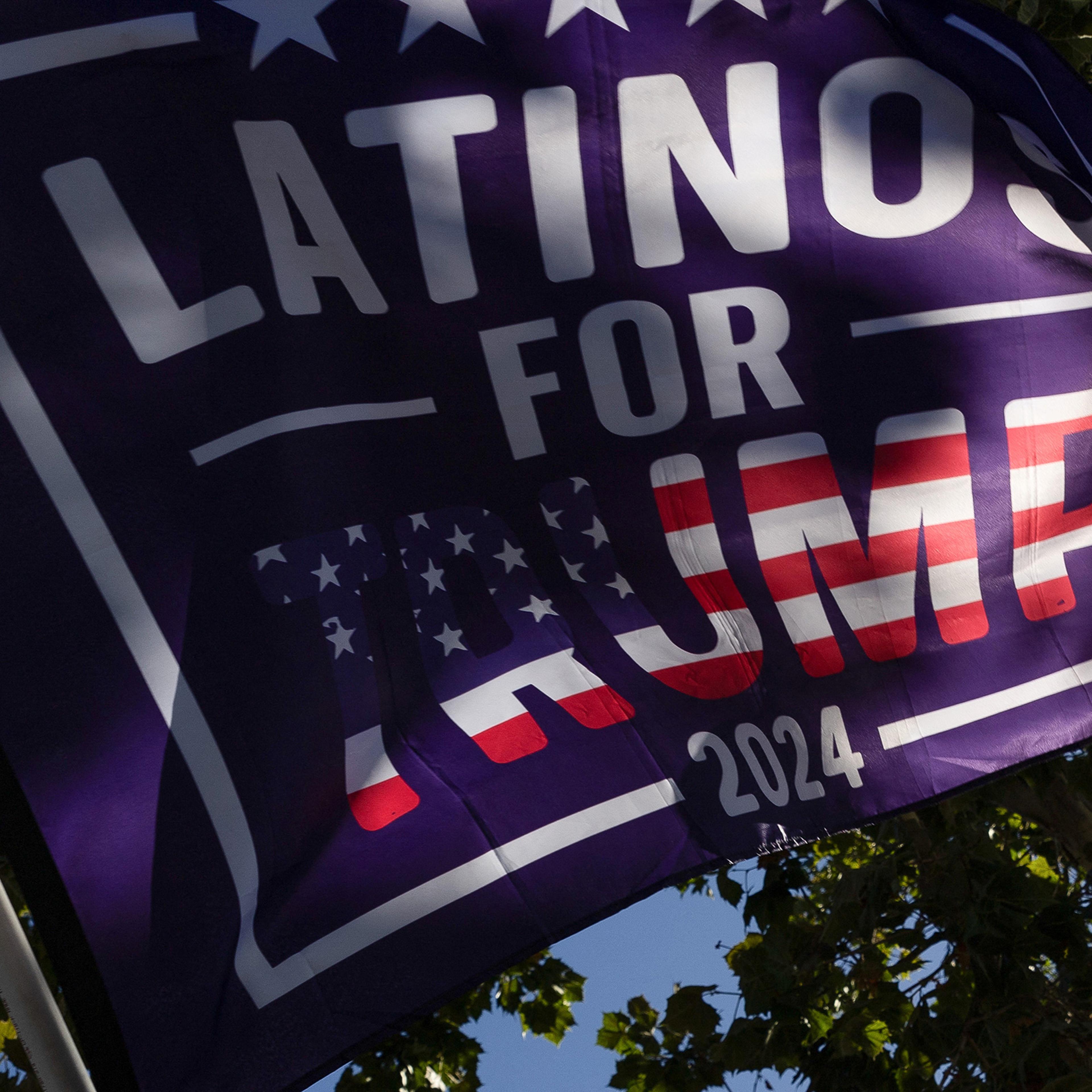 Supporters of Donald Trump hold a 'Latinos for Trump' flag before a fundraiser in Palo Alto, Calif., Sept. 13, 2024.