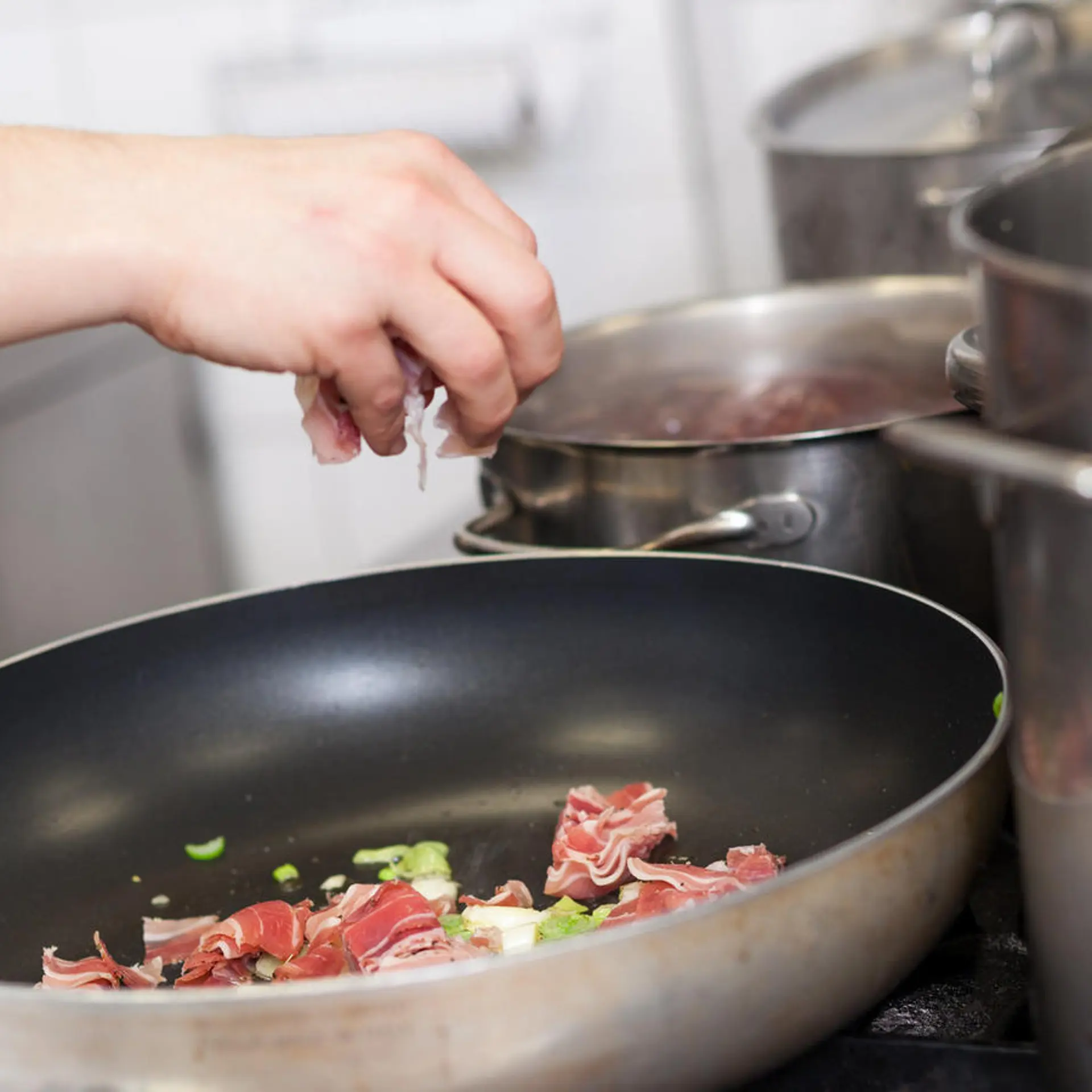 Chef or braising meat in a frying pan