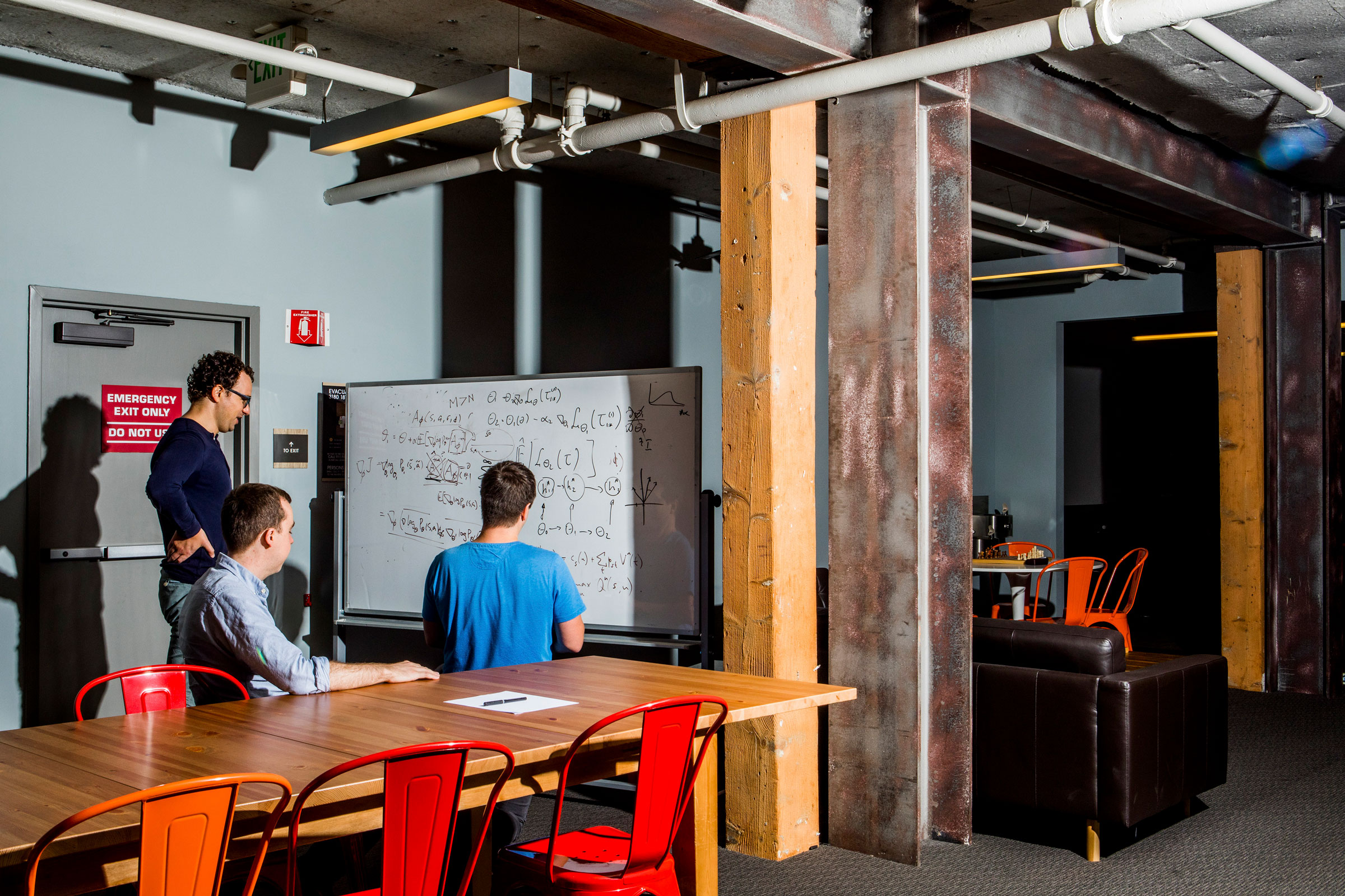 From left: Paul Christiano, Dario Amodei, and Geoffrey Irving write equations on a whiteboard at OpenAI, the artificial intelligence lab founded by Elon Musk, in San Francisco, July 10, 2017.