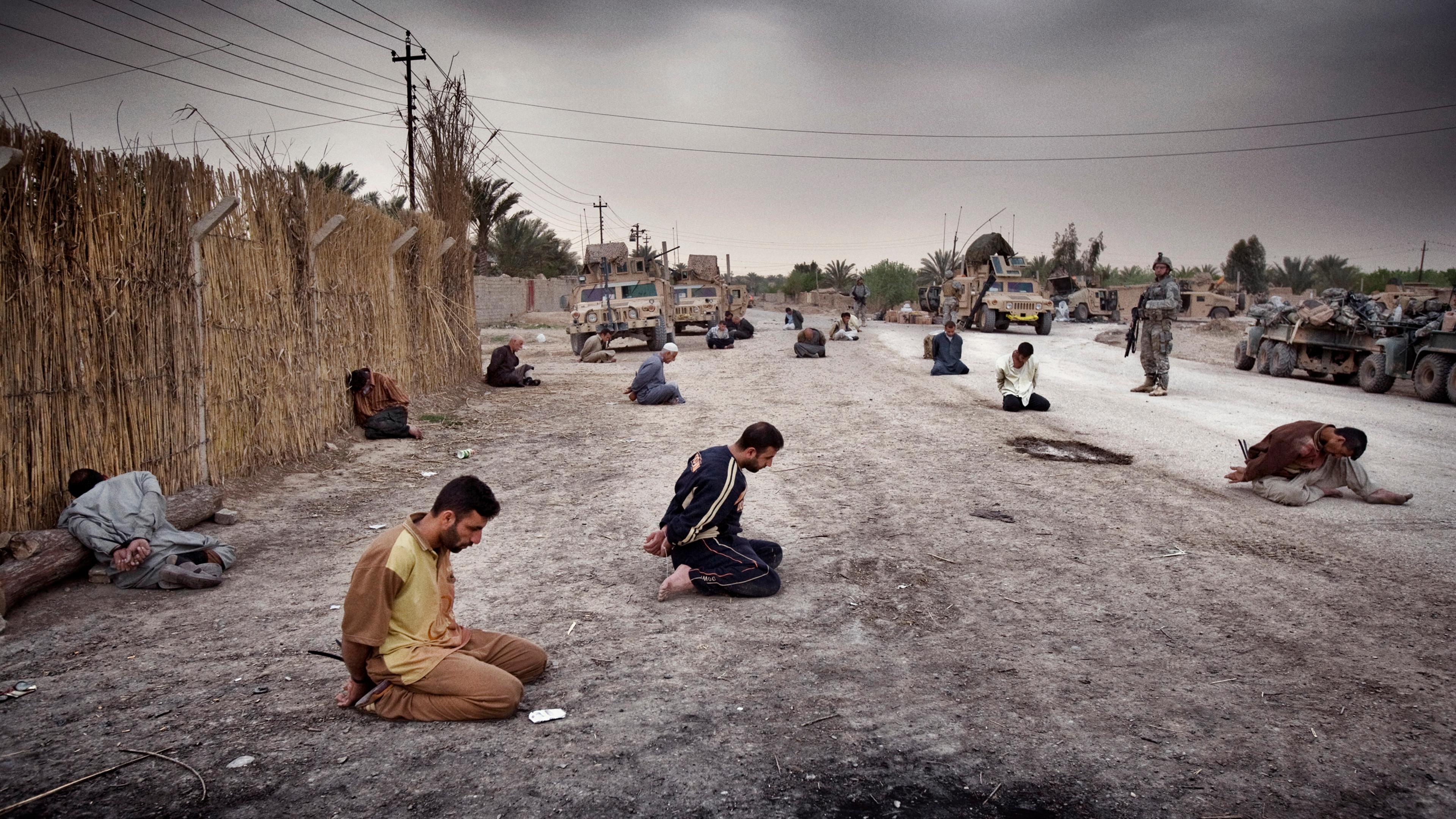 Men arrested by U.S. forces sit bound in the street after a roadside bomb attack in Qubah, Iraq, that left four Americans and one Iraqi boy dead, March 25, 2007.