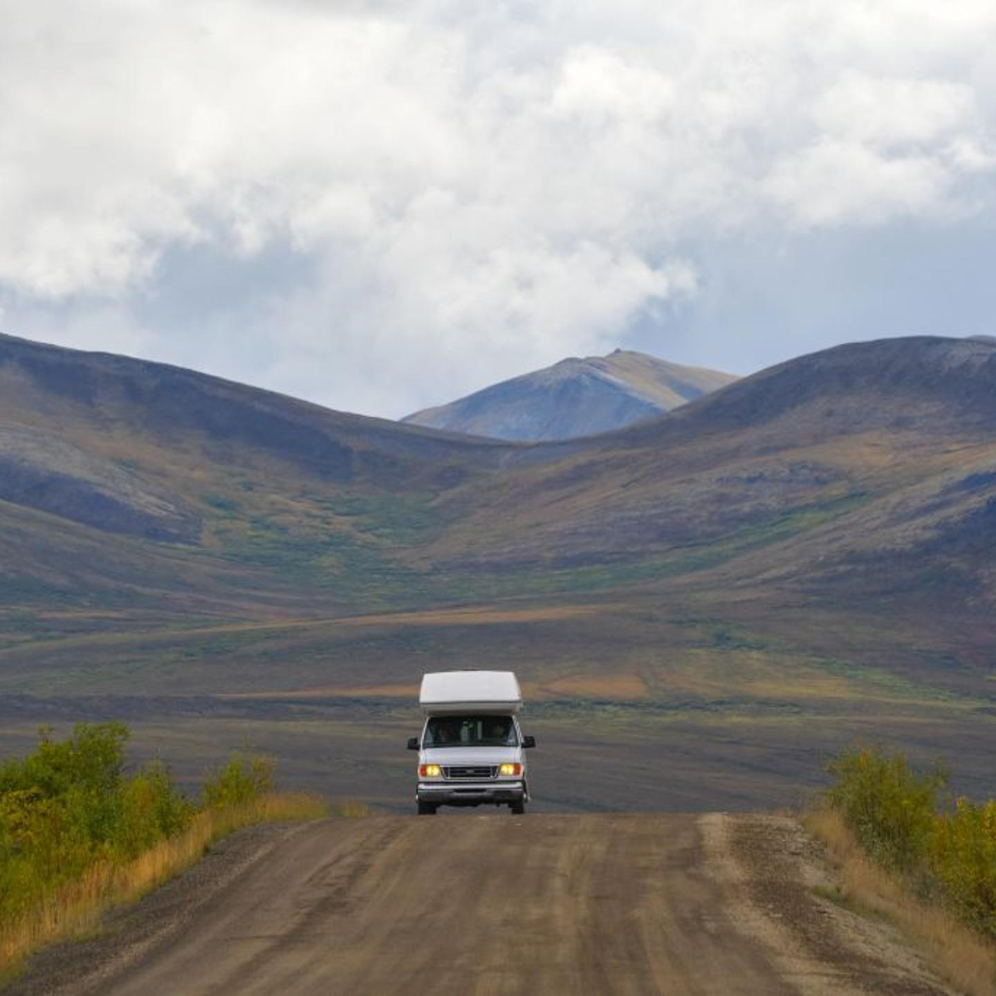 Small recreational vehicle driving the Dempster Highway near Dawson City, Yukon, Canada.