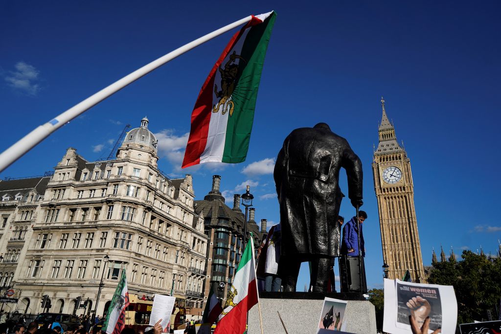 People wave flags and hold placards during a protest following the death of Mahsa Amini who died in custody of Iran's morality police, in London on Oct 8, 2022.