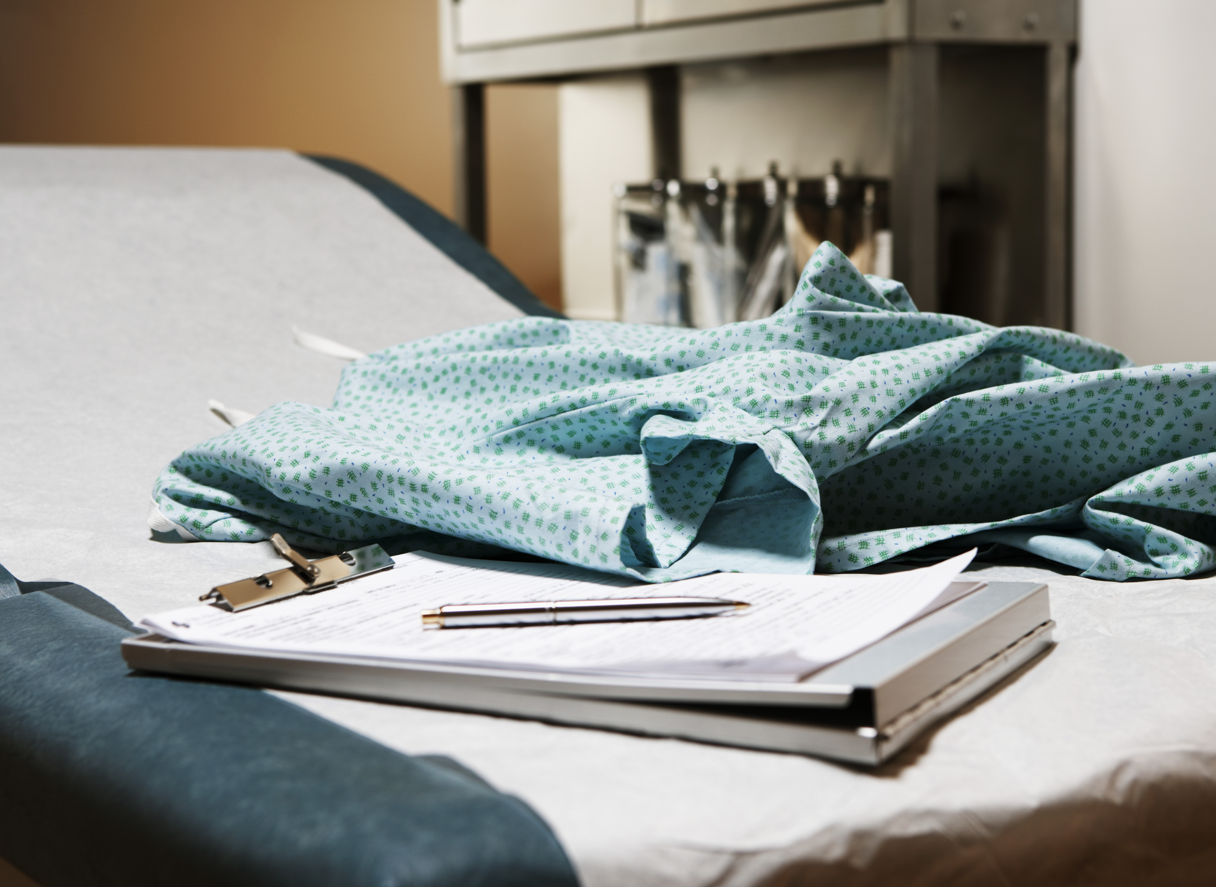Medical chart and examination gown on table in exam room