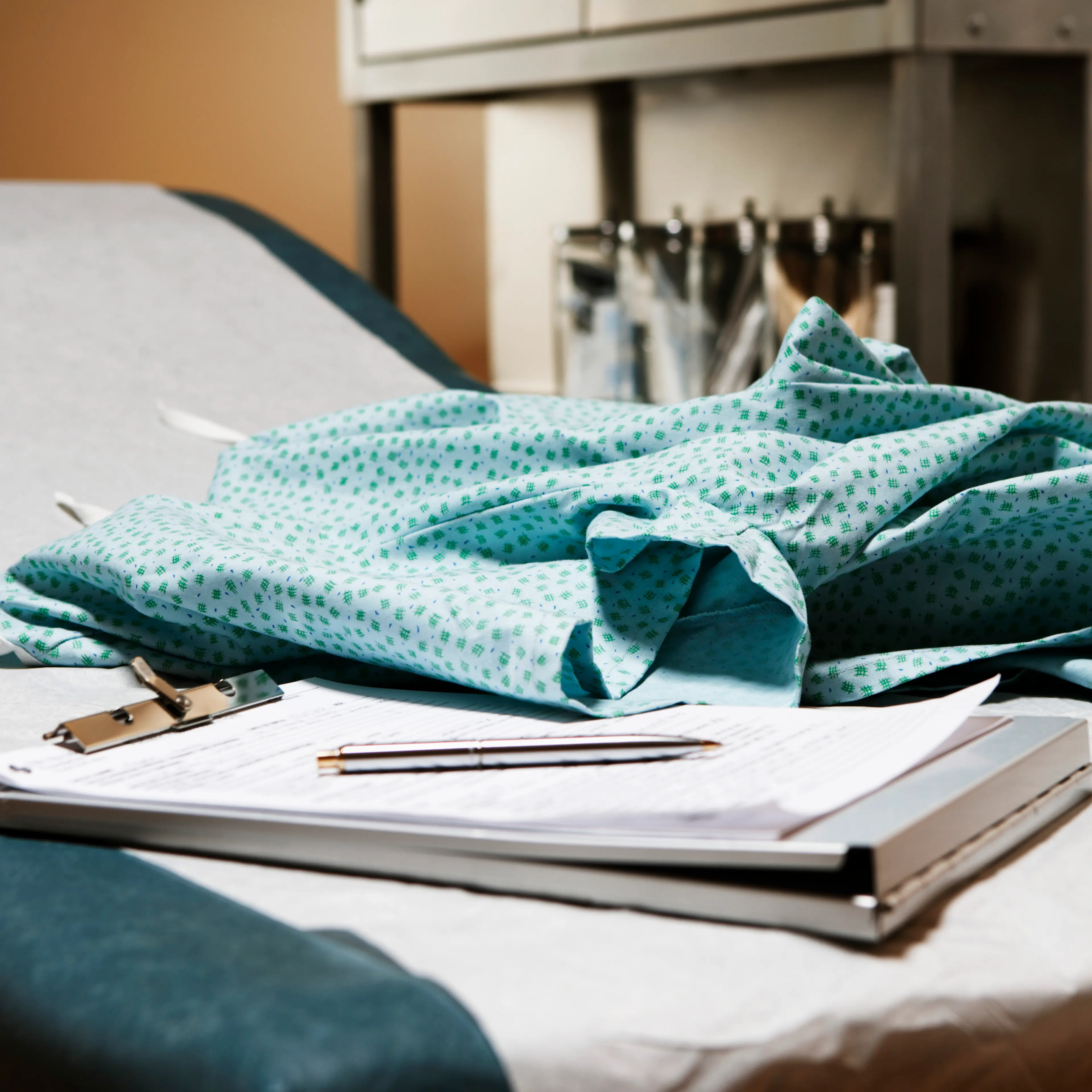 Medical chart and examination gown on table in exam room