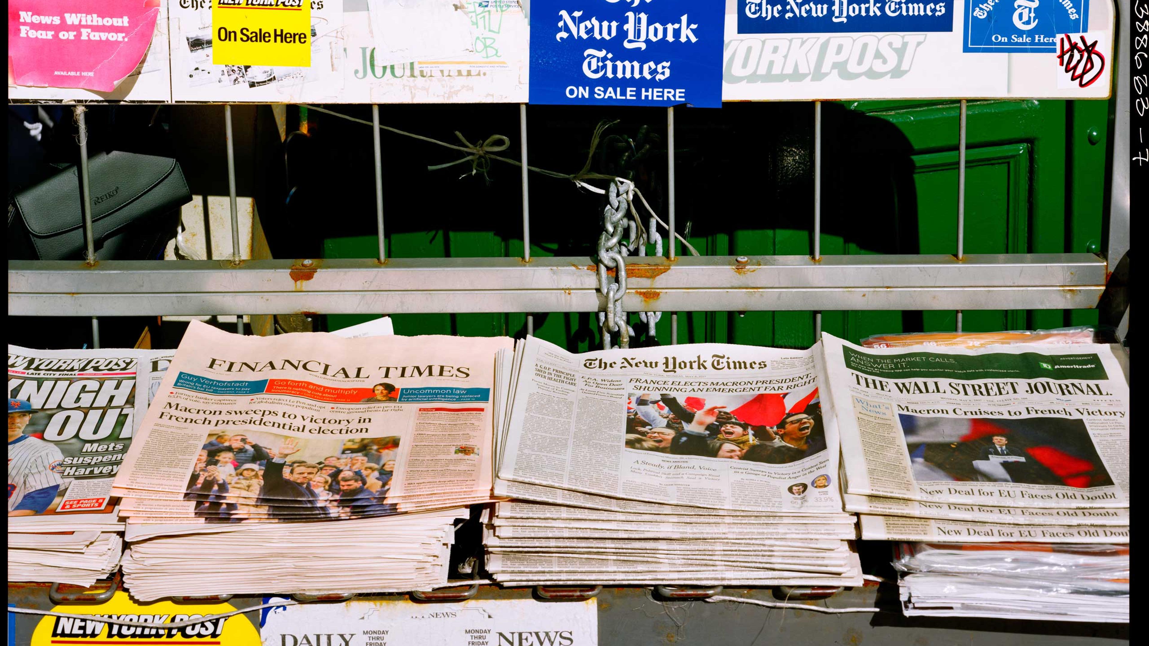 <b>Translation of caption from <i>Liberation:</i><b> May 8, 9 am, Union Square. It’s one of the rare remaining newsstands in the city. This morning, even the New York Post’s headline talks of the French election “FRANCE’S NEW LEADER, MACRON: Oui did it!” For the New York Times, it’s “SHUNNING AN EMERGENT FAR RIGHT.” France has elected Macron as its president while rejecting the emerging far right. Same story for the Wall Street Journal and the Financial Times: “MACRON CRUISES TO FRENCH VICTORY” and “MACRON SWEEPS TO VICTORY”. Macron sails to a victory and wins the presidential election. The city is in a good mood. It’s chilly out, but the sun is shining.
