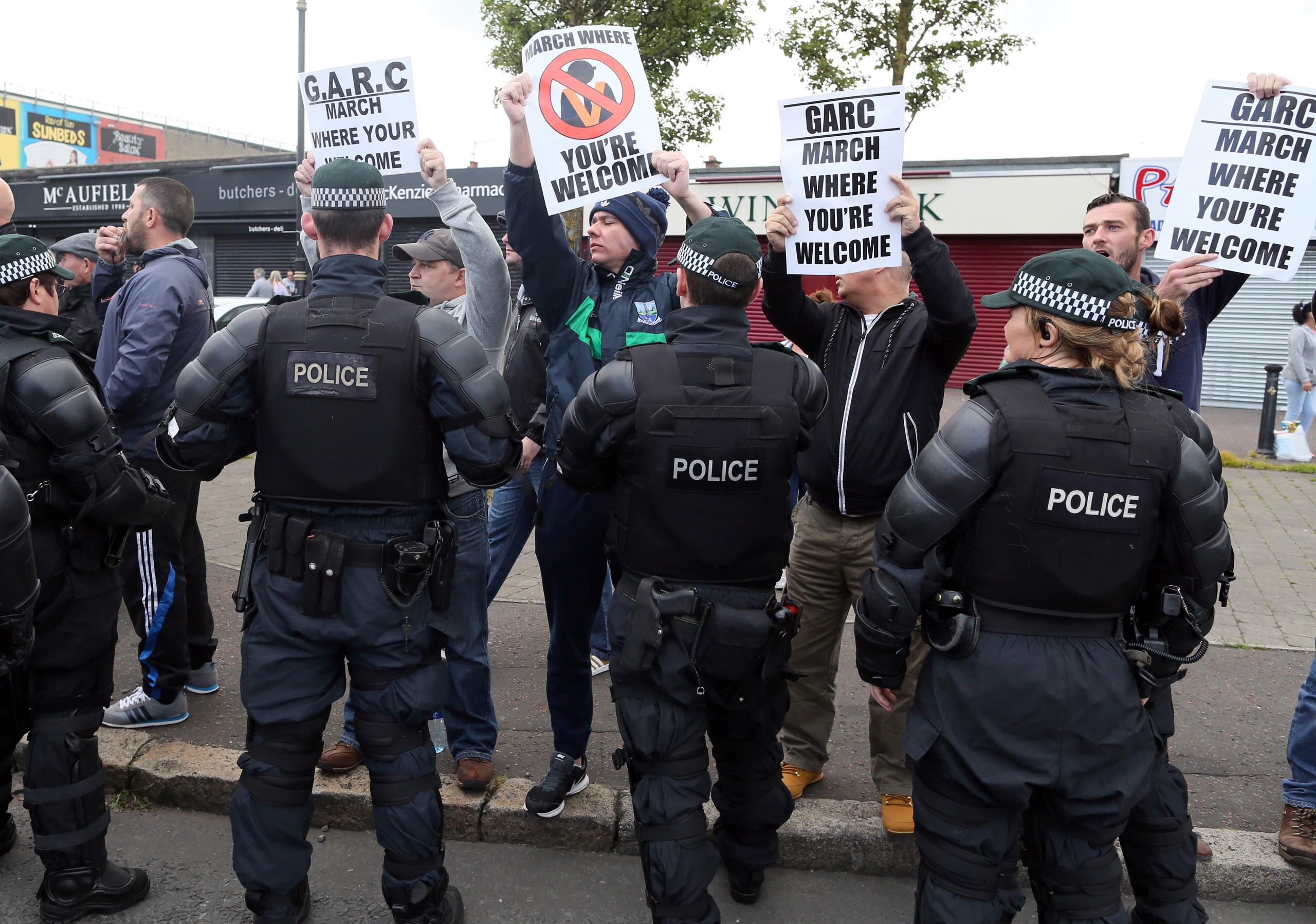 The police keep Nationalist protestors away from a Loyalist feeder parade as it passes the Nationalist Ardoyne shops on its way to join the main 12th July celebrations inn Belfast, Northern Ireland on July 12, 2016.