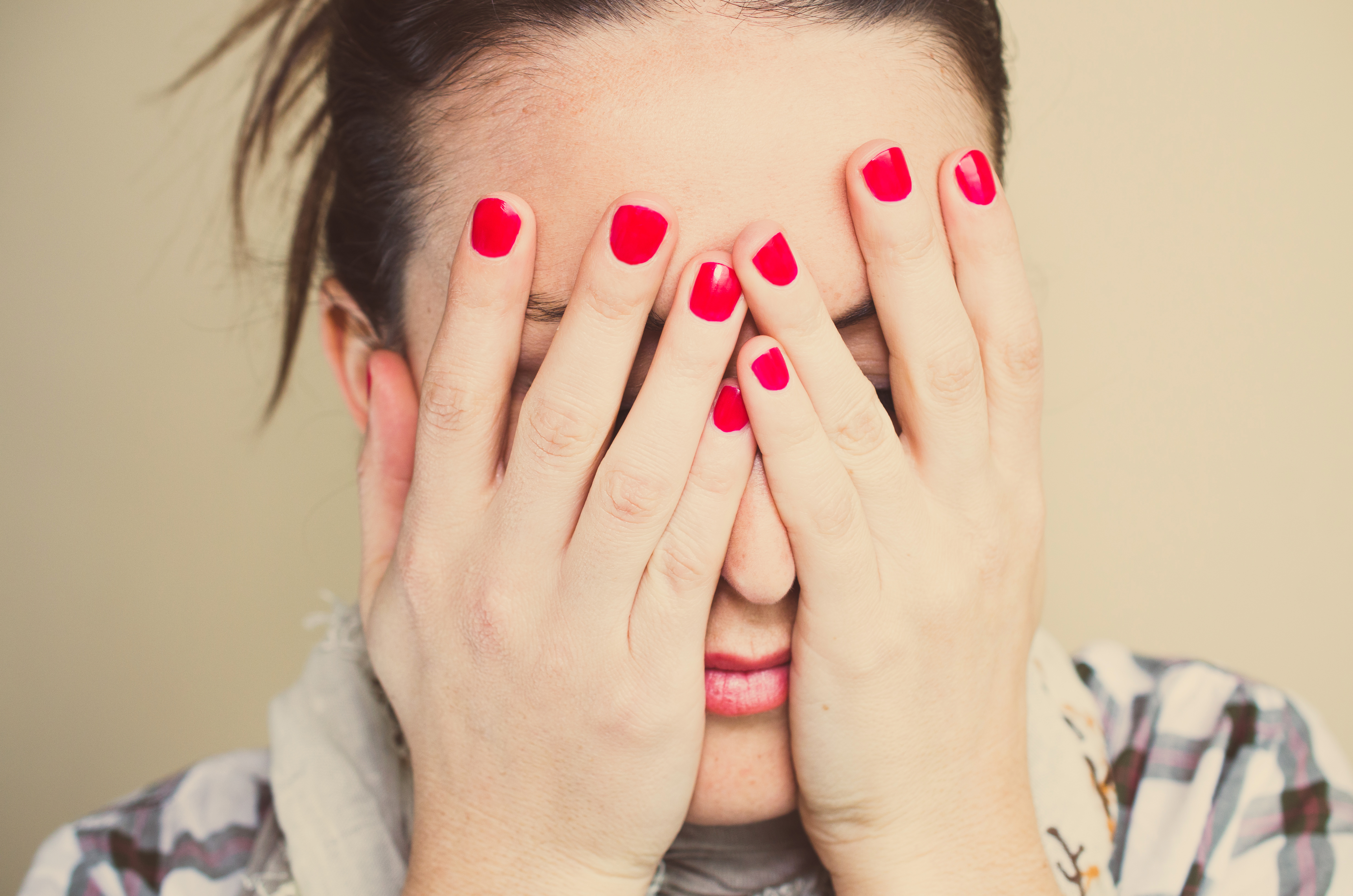 Worried. Girl with hands on face and red nails
