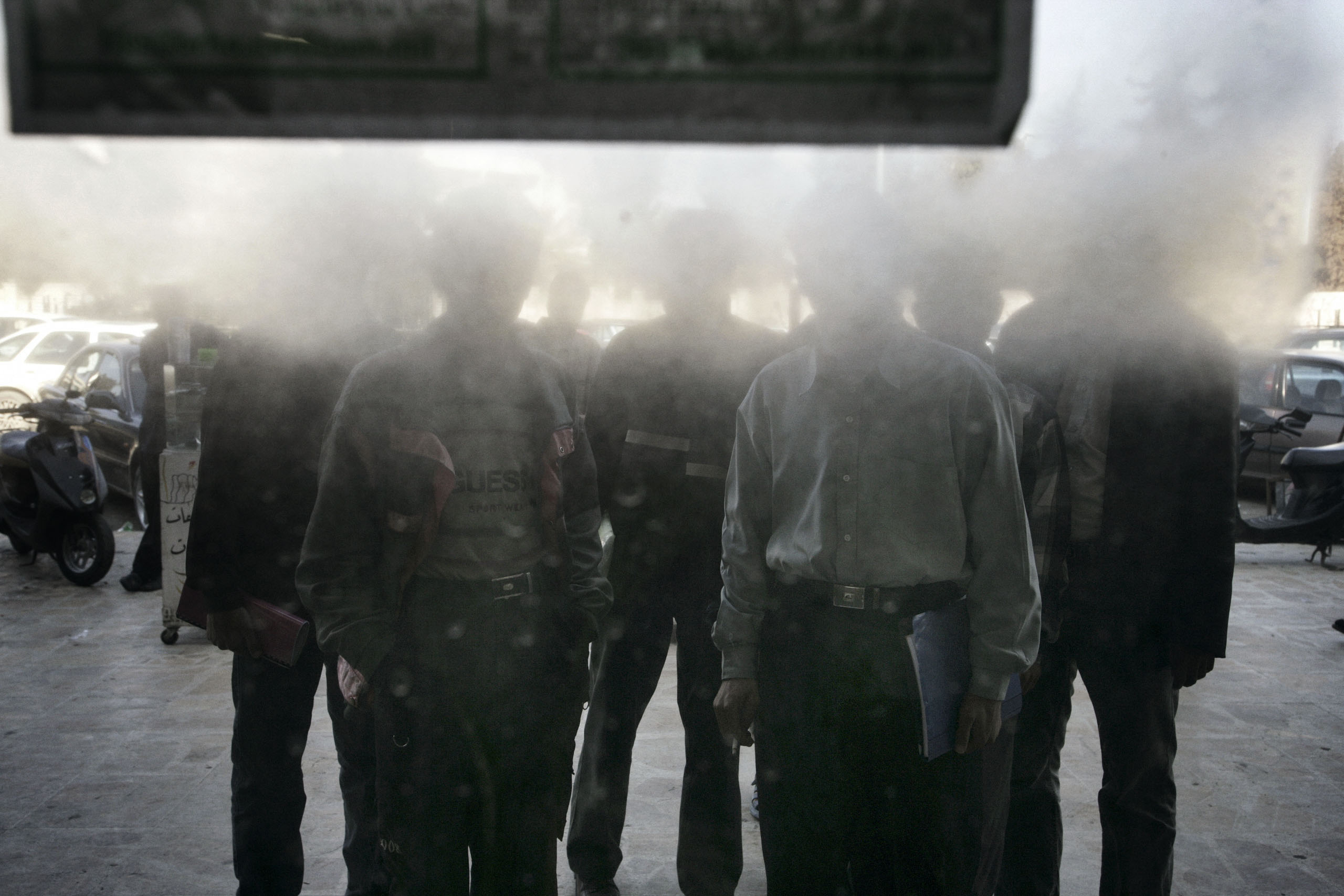 Men read a sign posted in the window of a Mosul, Iraq, tea house proclaiming that the shop's owner has been aiding terrorists, Feb. 23, 2005.