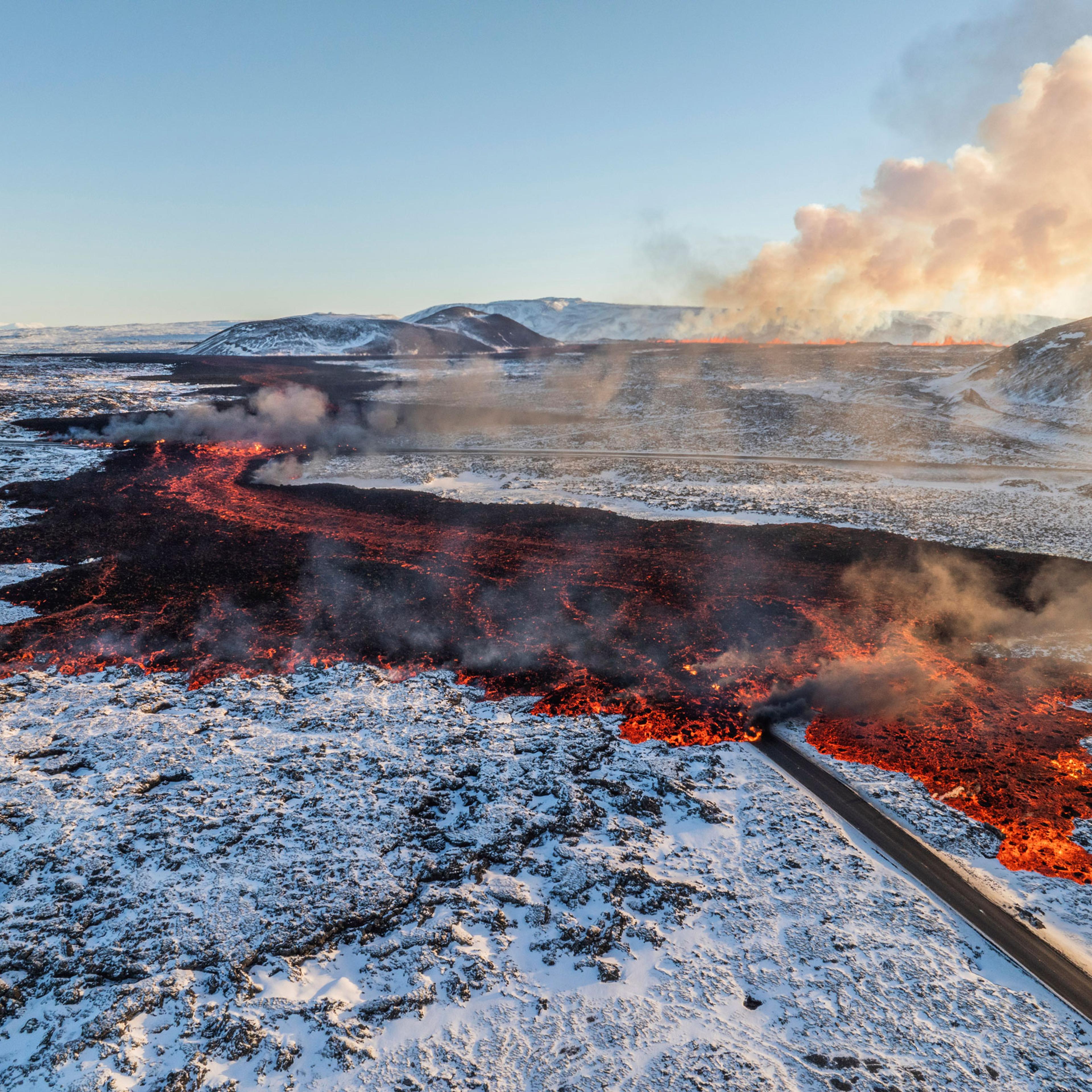 A view of lava crossing the main road to Grindavík and flowing on the road leading to the Blue Lagoon, in Grindavík, Iceland