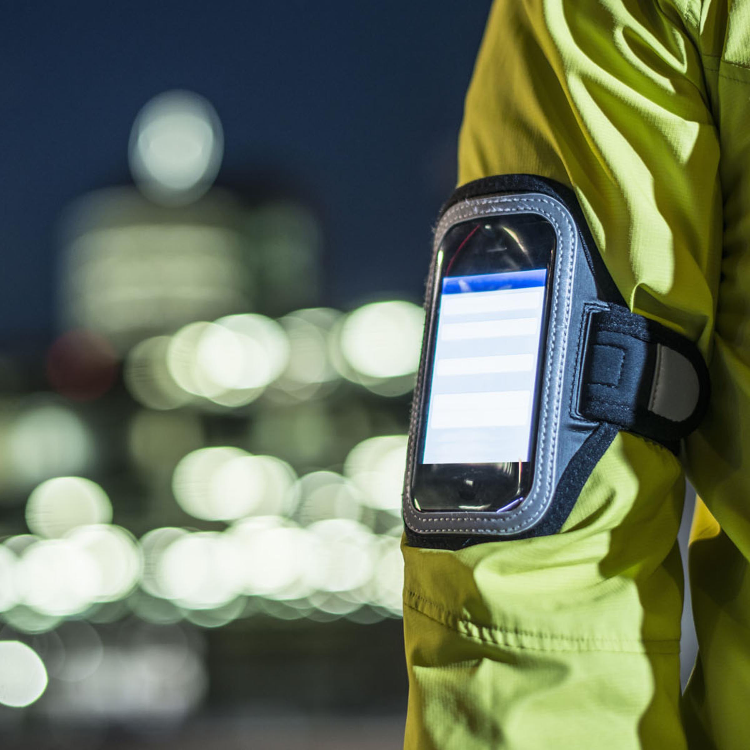 A runner wears a smartphone on his arm.