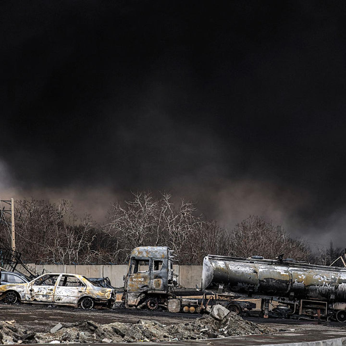 A dark smoke cloud engulfs destroyed vehicles near an ongoing fire following an Israeli airstrike on the Shahran oil refinery in northwestern Tehran, Iran, on March 8, 2026.