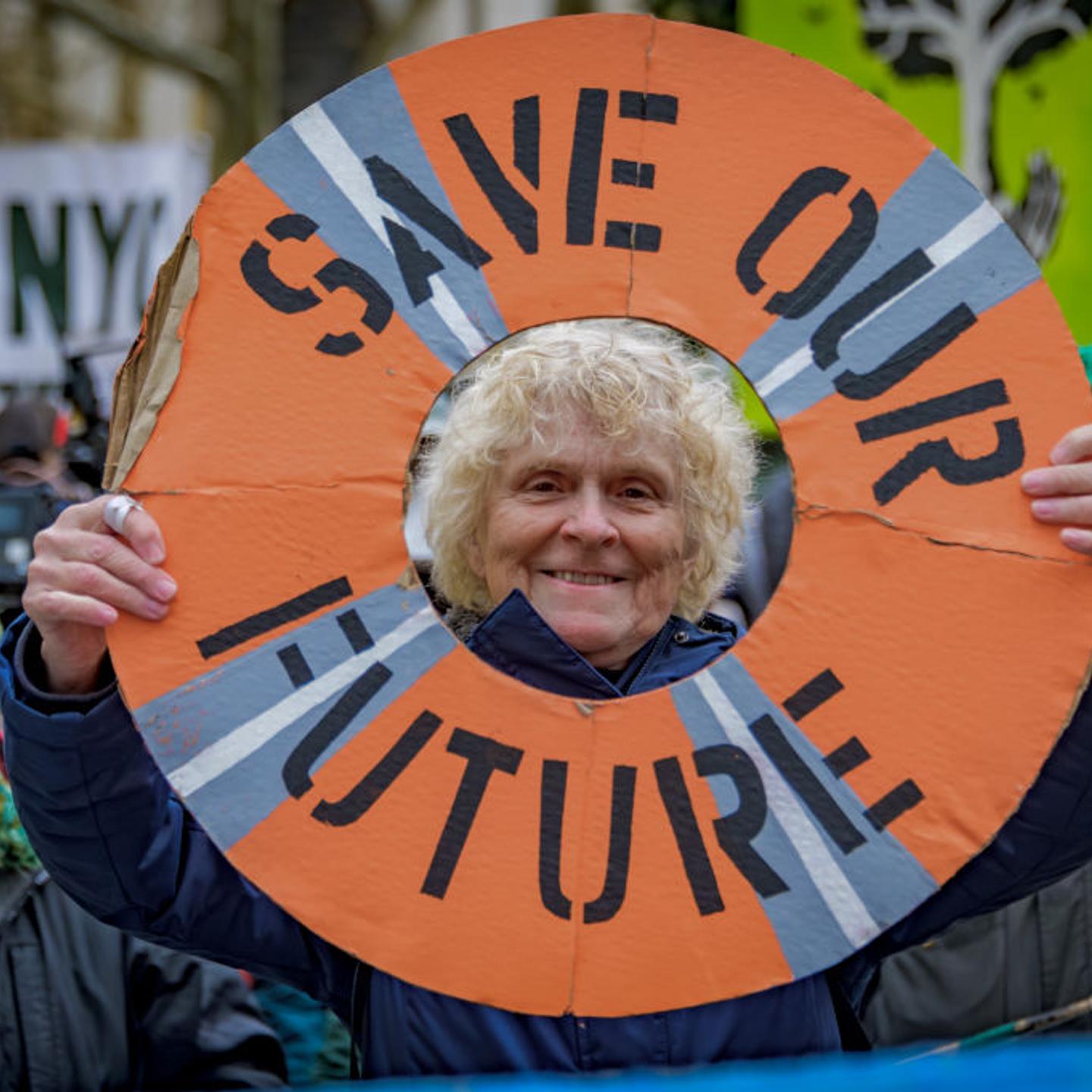 Participant seen holding a sign at the protest. Climate