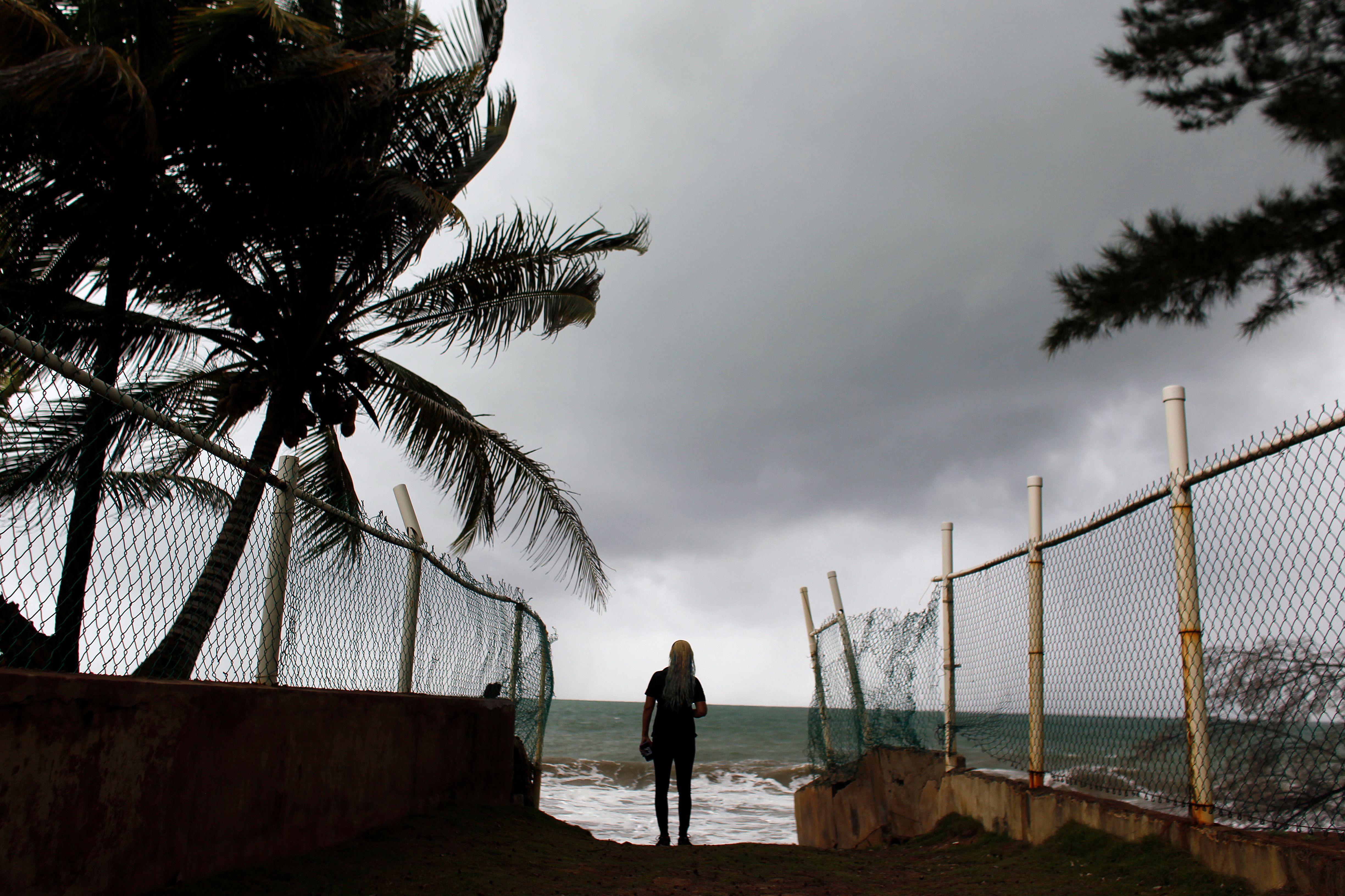 A woman looks at heavy surf as Hurricane Irma approaches Puerto Rico in Luquillo, on September 6, 2017.