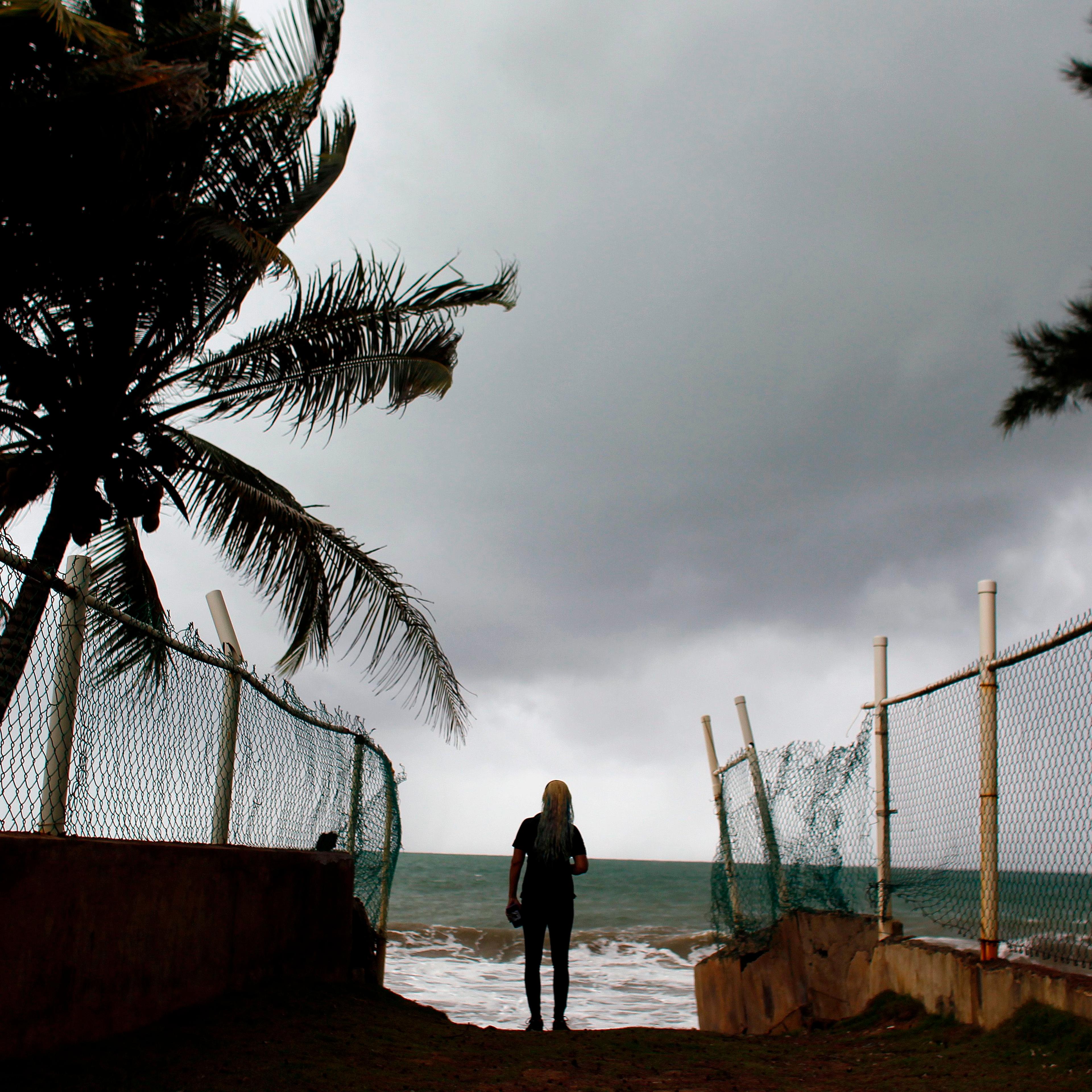 A woman looks at heavy surf as Hurricane Irma approaches Puerto Rico in Luquillo, on September 6, 2017.
