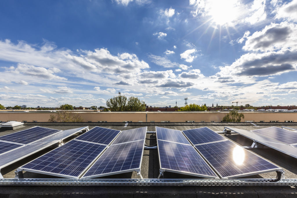 Solar panels sit on the roof of an apartment block in Germany.