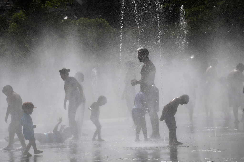 People enjoy and cool off in the water of the Madrid Rio