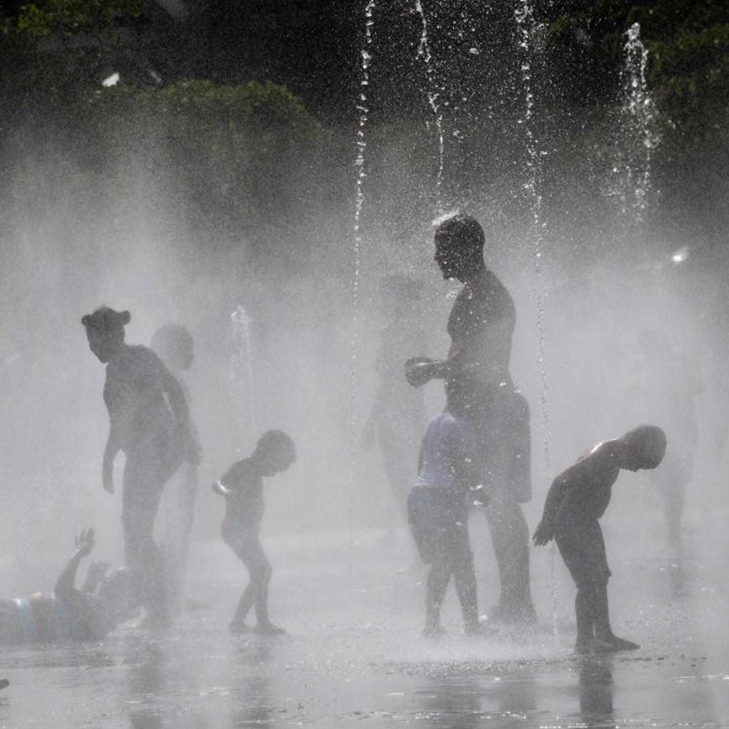 People enjoy and cool off in the water of the Madrid Rio