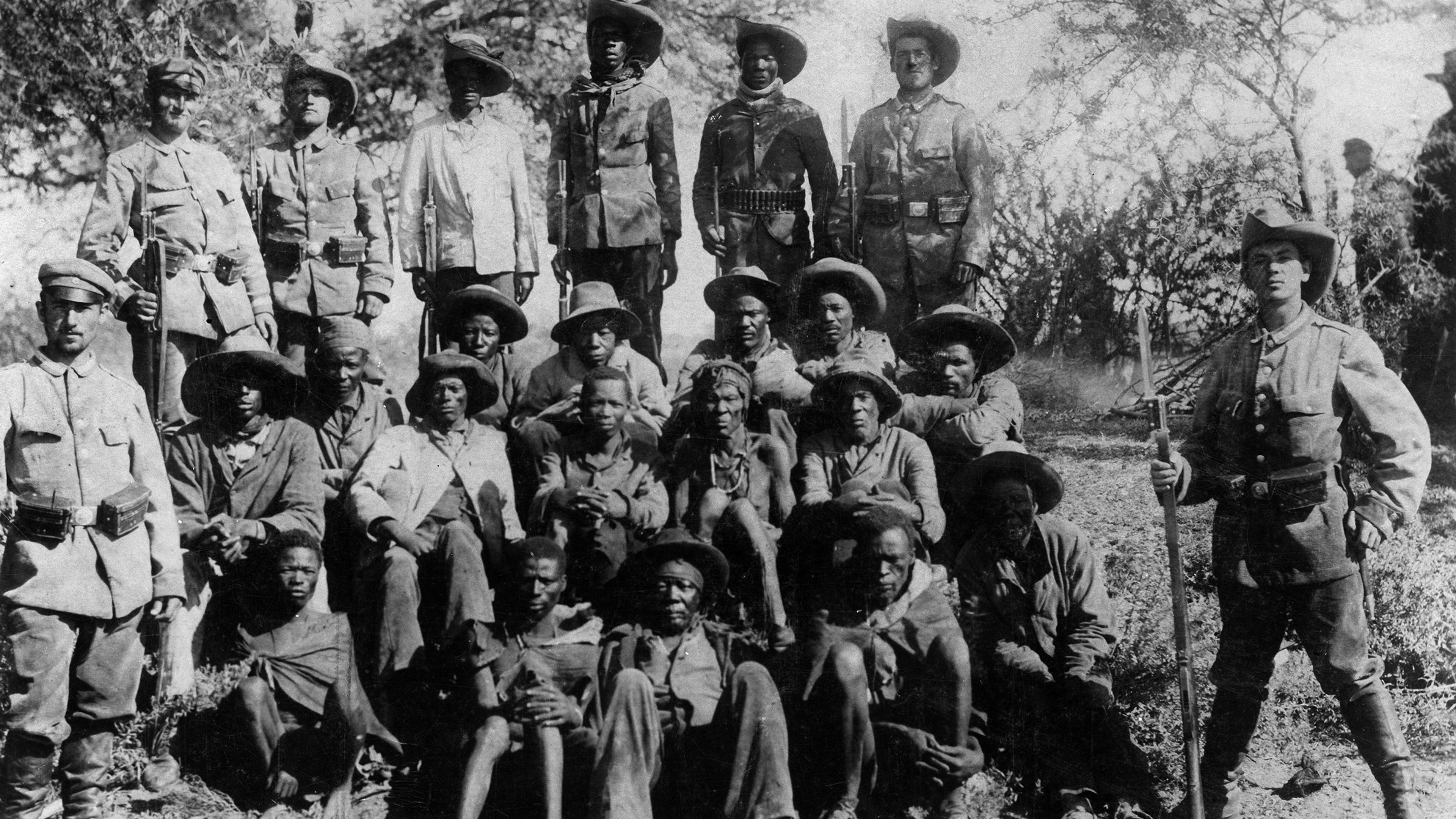 German soldiers pose with captured Nama - Hottentots, circa 1905.