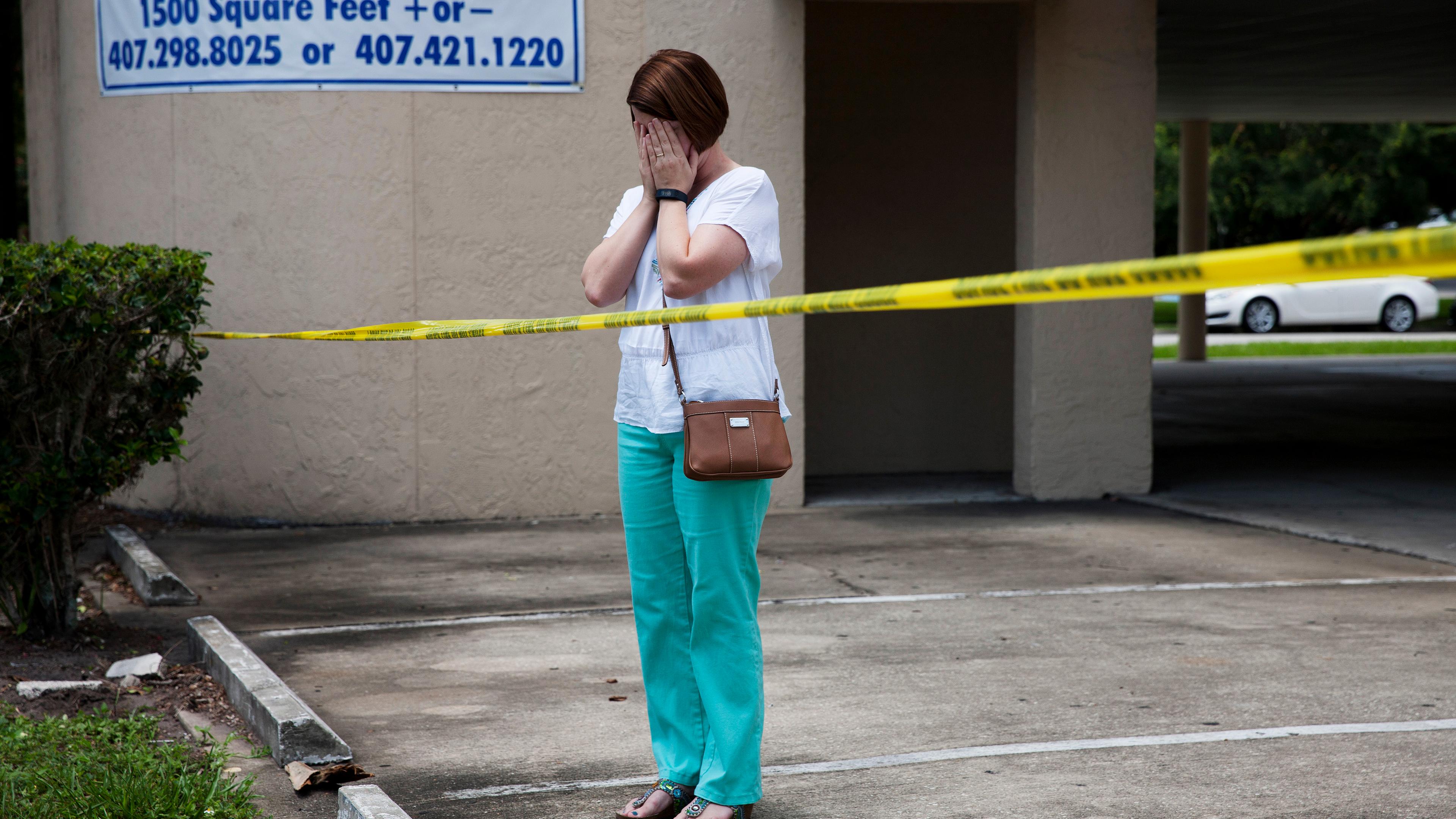 A woman reacts as authorities investigate Pulse following a mass shooting in Orlando, Fla., on June 12, 2016.