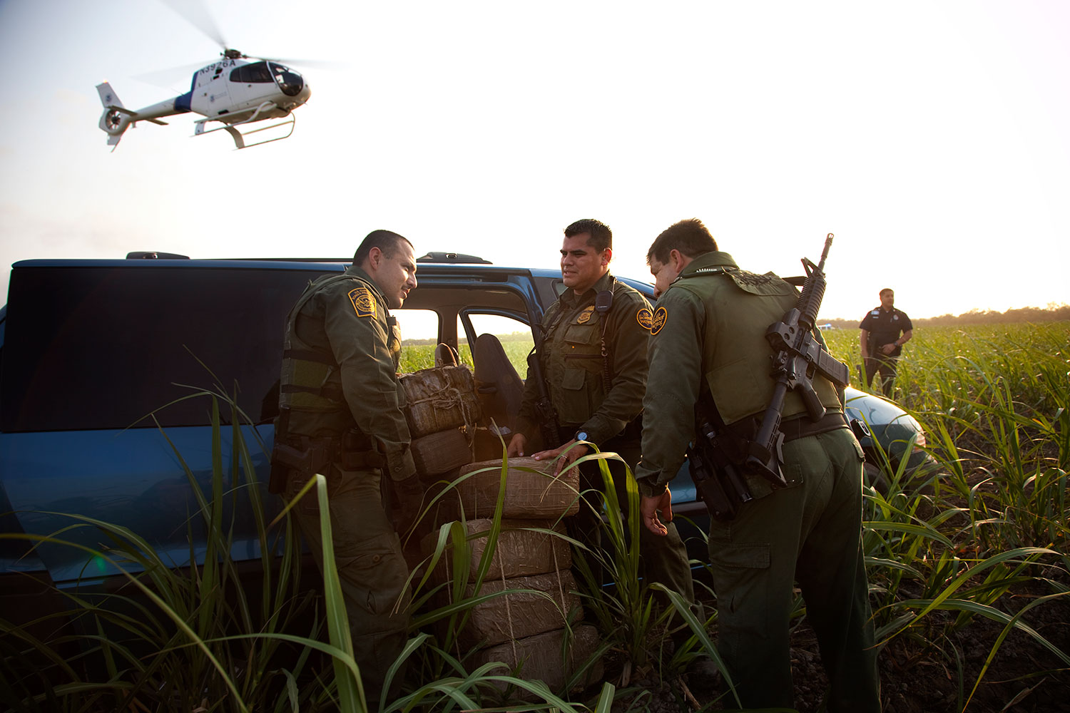 Border Patrol officers inspect the inside of a van filled with roughly 800 pounds of marijuana after a car chase that included helicopter assistance. Authorities were able to eventually stop the suspect who was trying to race the car and the drugs back to the Mexican border. He was stopped and arrested in this field in McAllen, Texas less than a mile from the border. Helicopter units constantly patrol this narco trafficking hot spot in an effort to slow down the activity of drug smuggling in the area. April 23, 2011