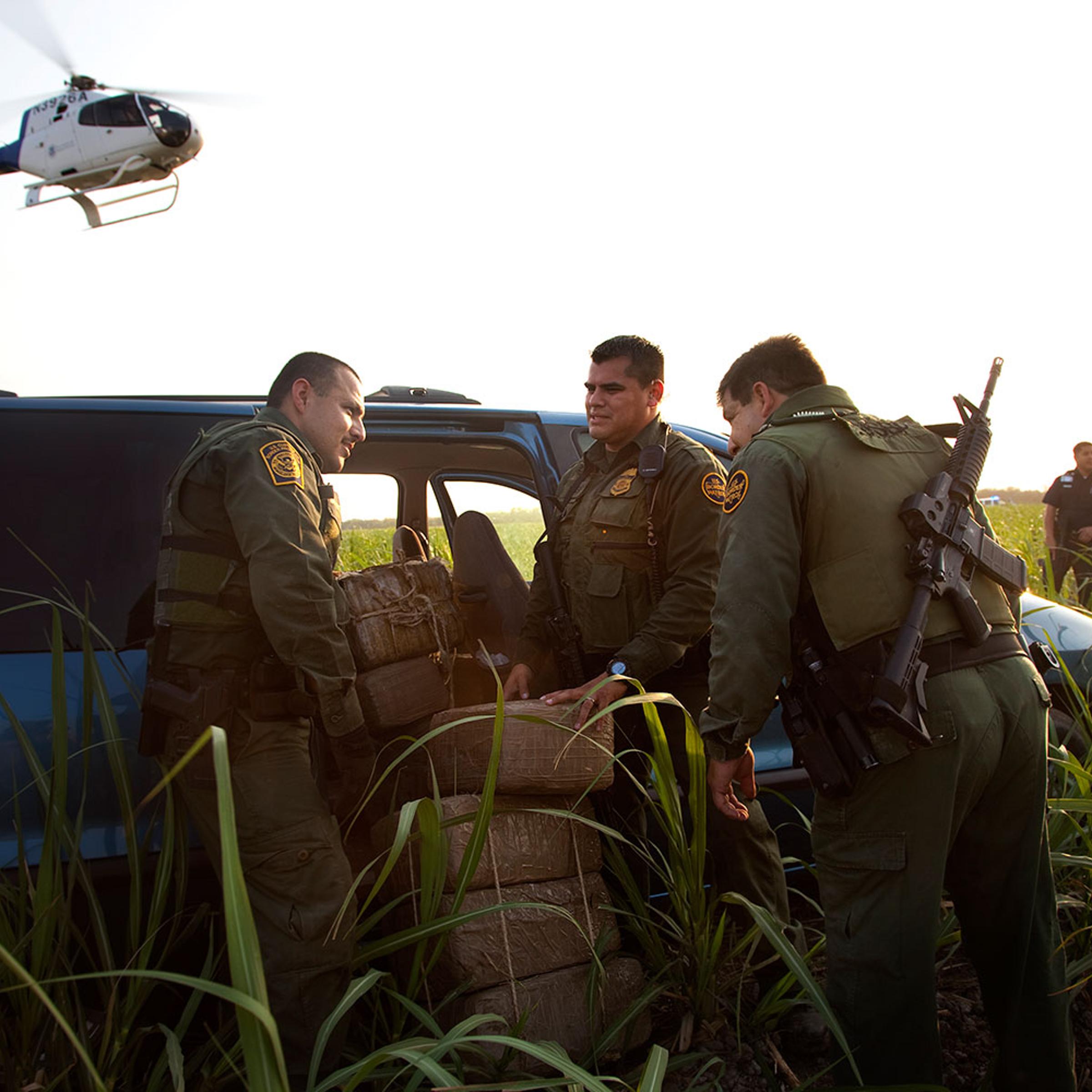 Border Patrol officers inspect the inside of a van filled with roughly 800 pounds of marijuana after a car chase that included helicopter assistance. Authorities were able to eventually stop the suspect who was trying to race the car and the drugs back to the Mexican border. He was stopped and arrested in this field in McAllen, Texas less than a mile from the border. Helicopter units constantly patrol this narco trafficking hot spot in an effort to slow down the activity of drug smuggling in the area. April 23, 2011