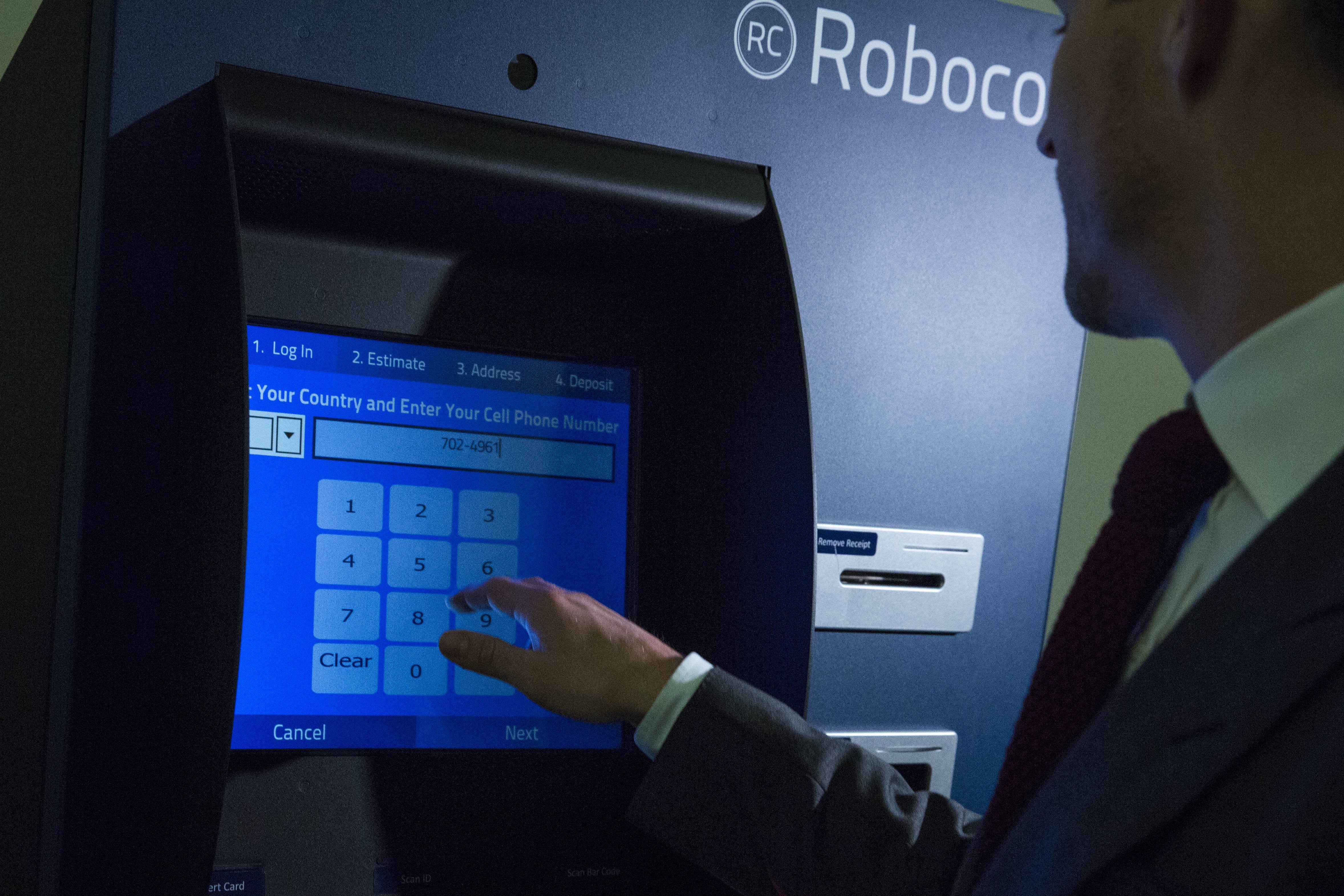 Representatives Of A Bitcoin Kiosk Company Demonstrate The Currency Product On Capitol Hill