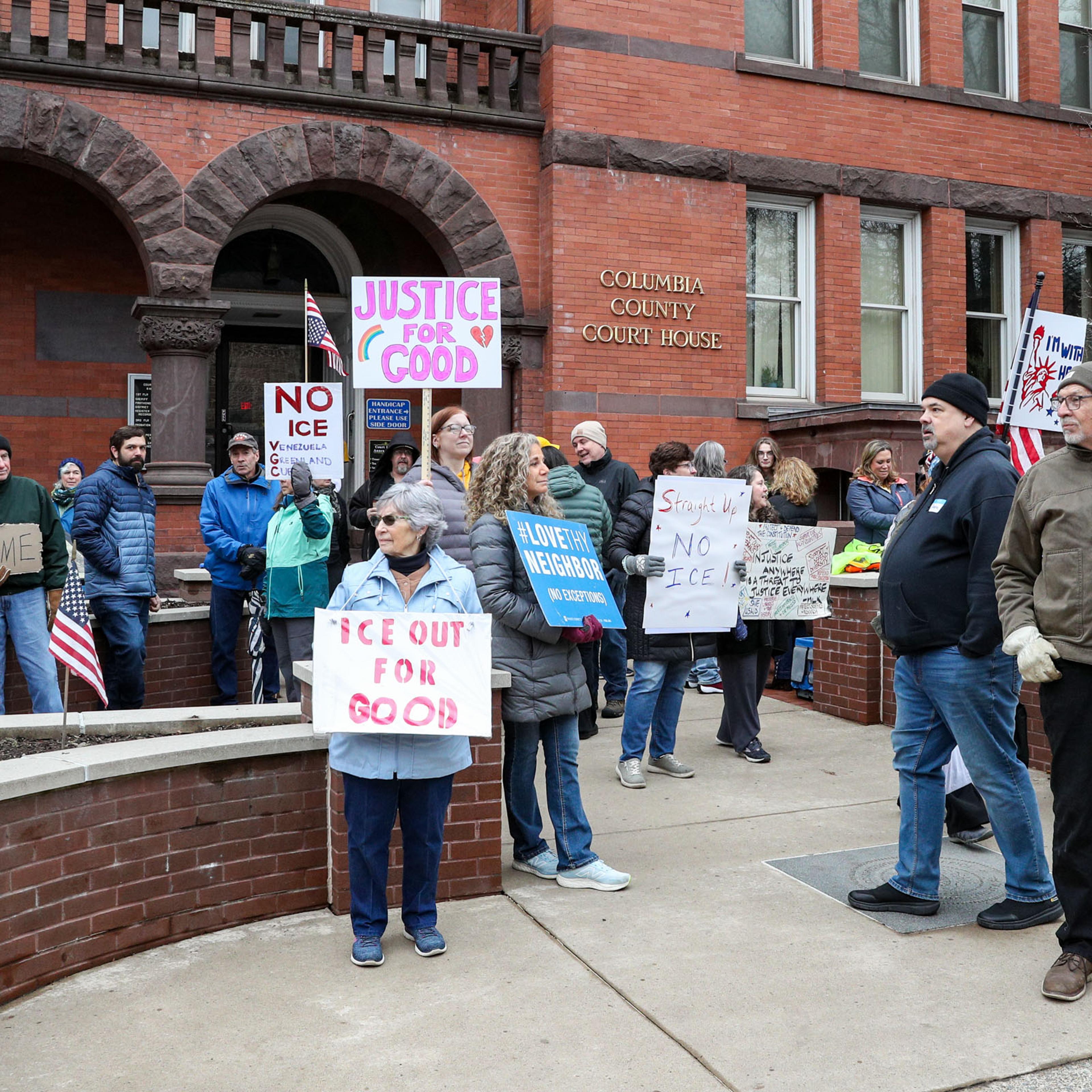 Anti-ICE demonstrators hold placards during the "ICE Out for