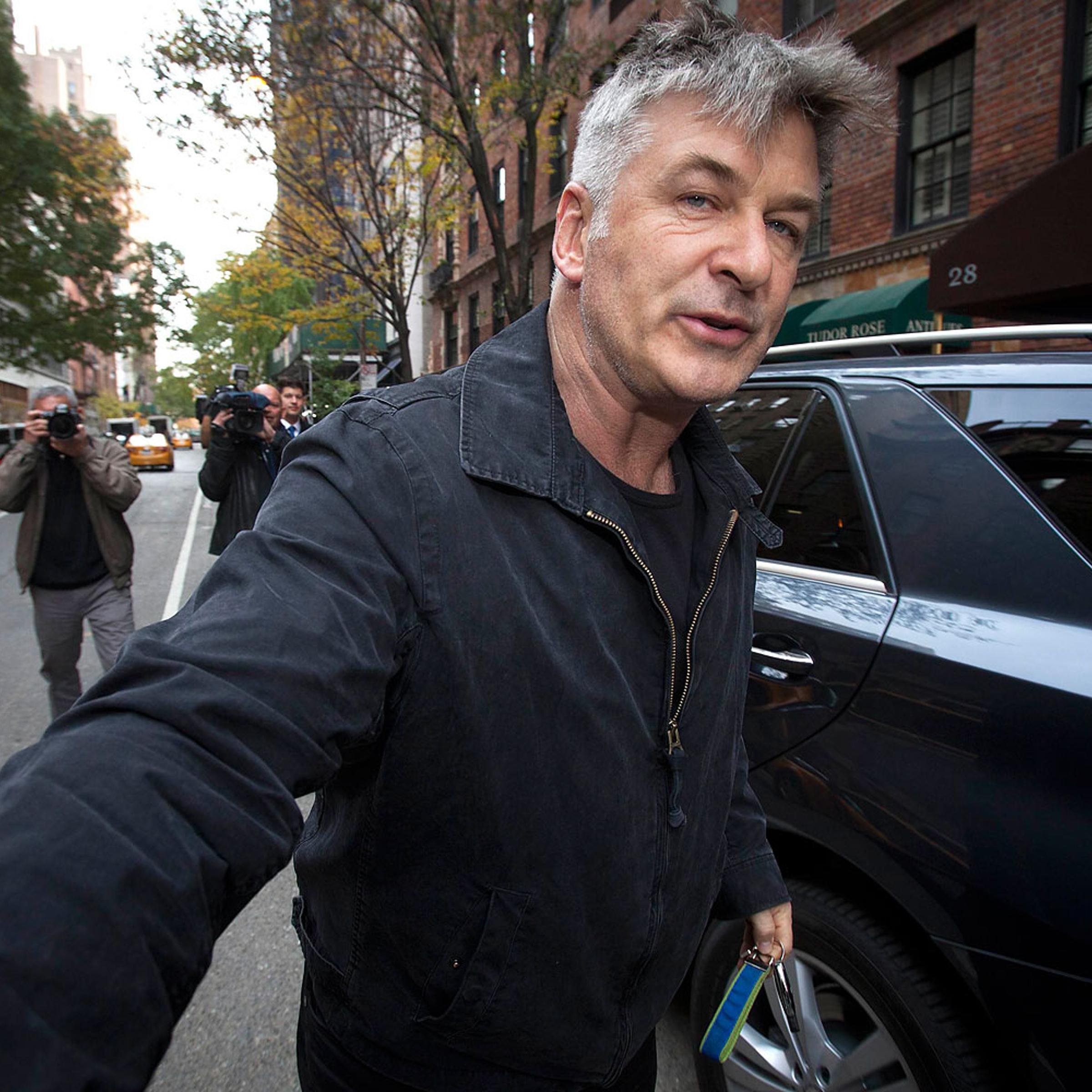 Actor Alec Baldwin shoves a photographer and tells him to move out of his way after he arrived in his SUV at the building where he lives in New York
