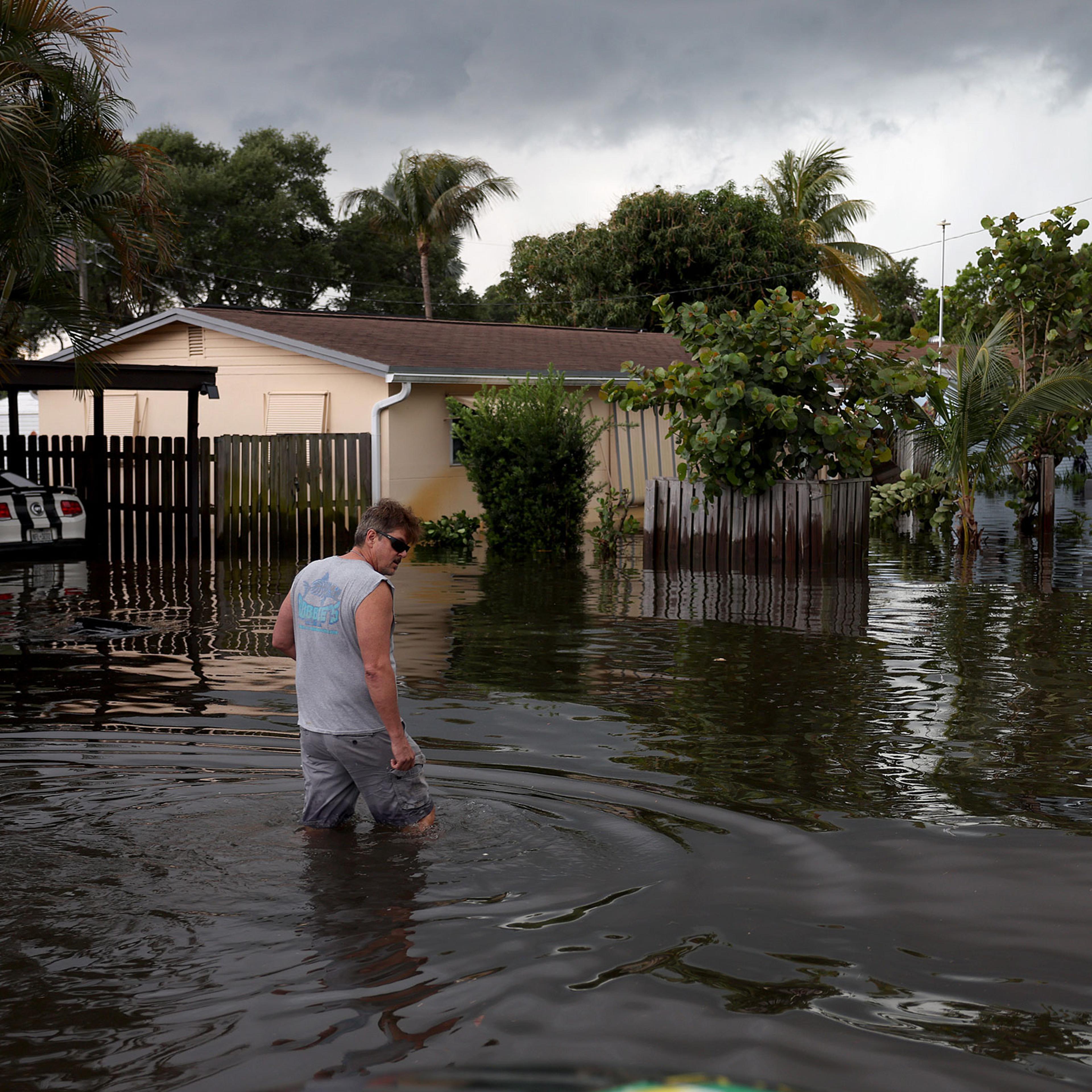 A person walks through a flooded street in Fort Lauderdale, Fla., on April 13, 2023.