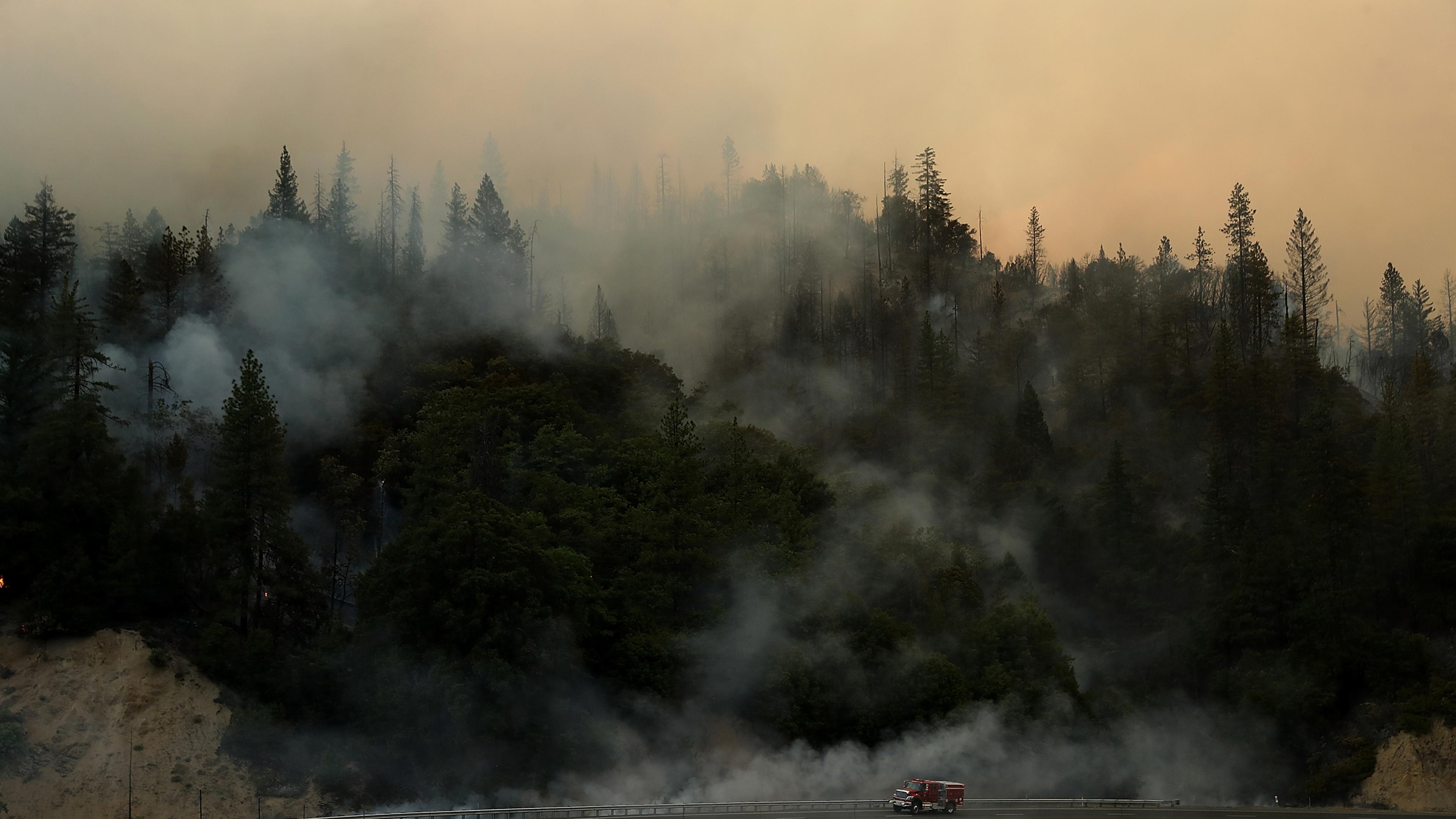 A Cal Fire truck drives along highway 299 as the Carr Fire burns in the hills near Whiskeytown, Calif. on July 28.