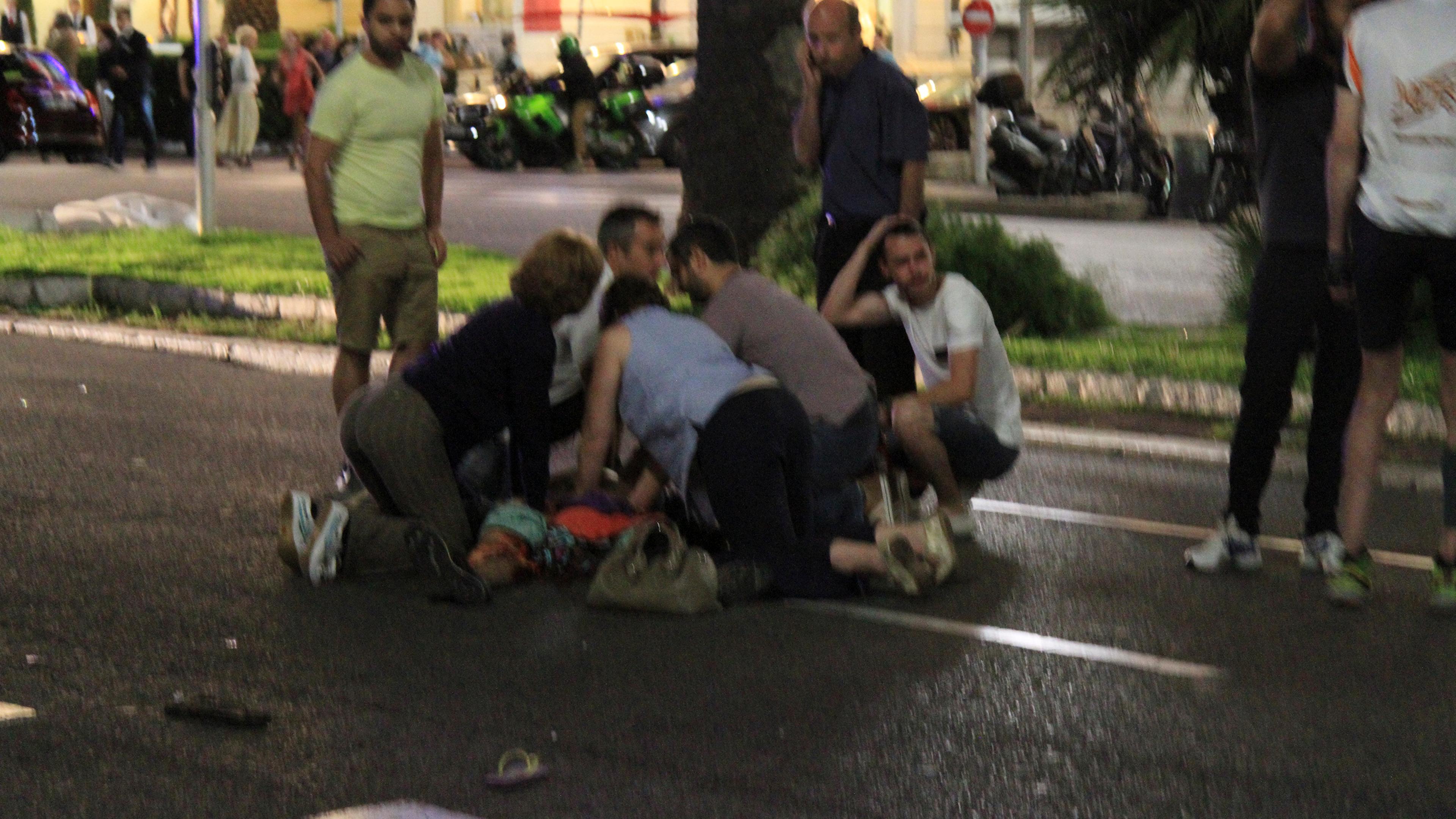 Bystanders tend to victims after a terrorist attack in Nice, France, that left 77 dead and many more injured, July 14, 2016