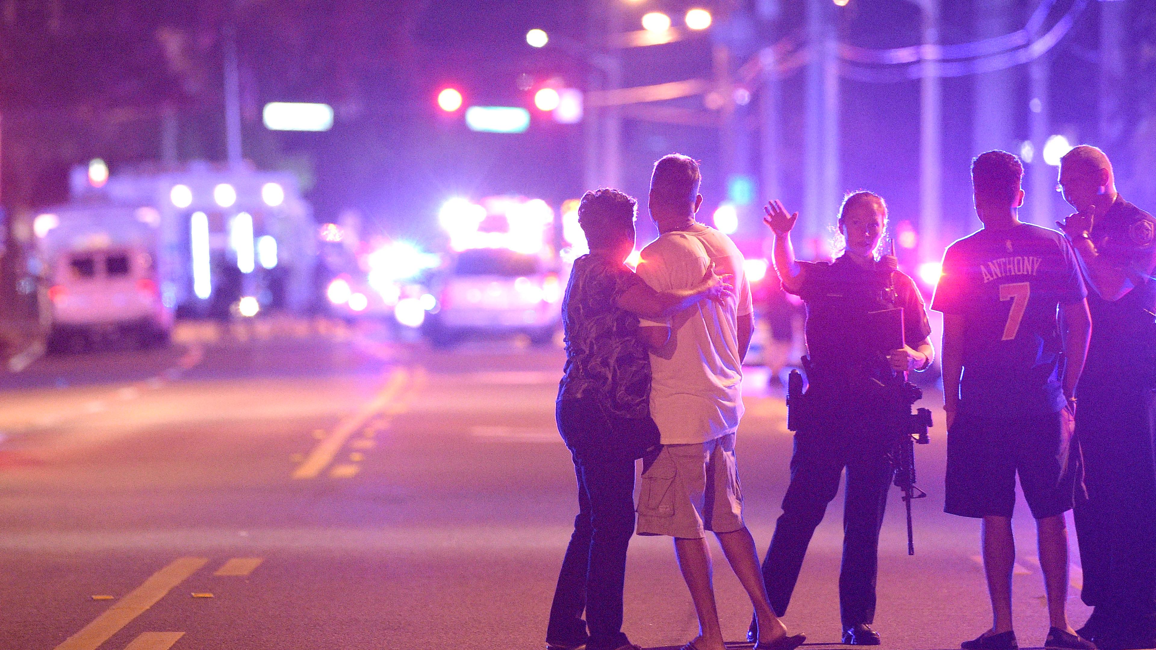 Police officers direct family members away from a shooting at Pulse nightclub in Orlando, Fla., on June 12, 2016.