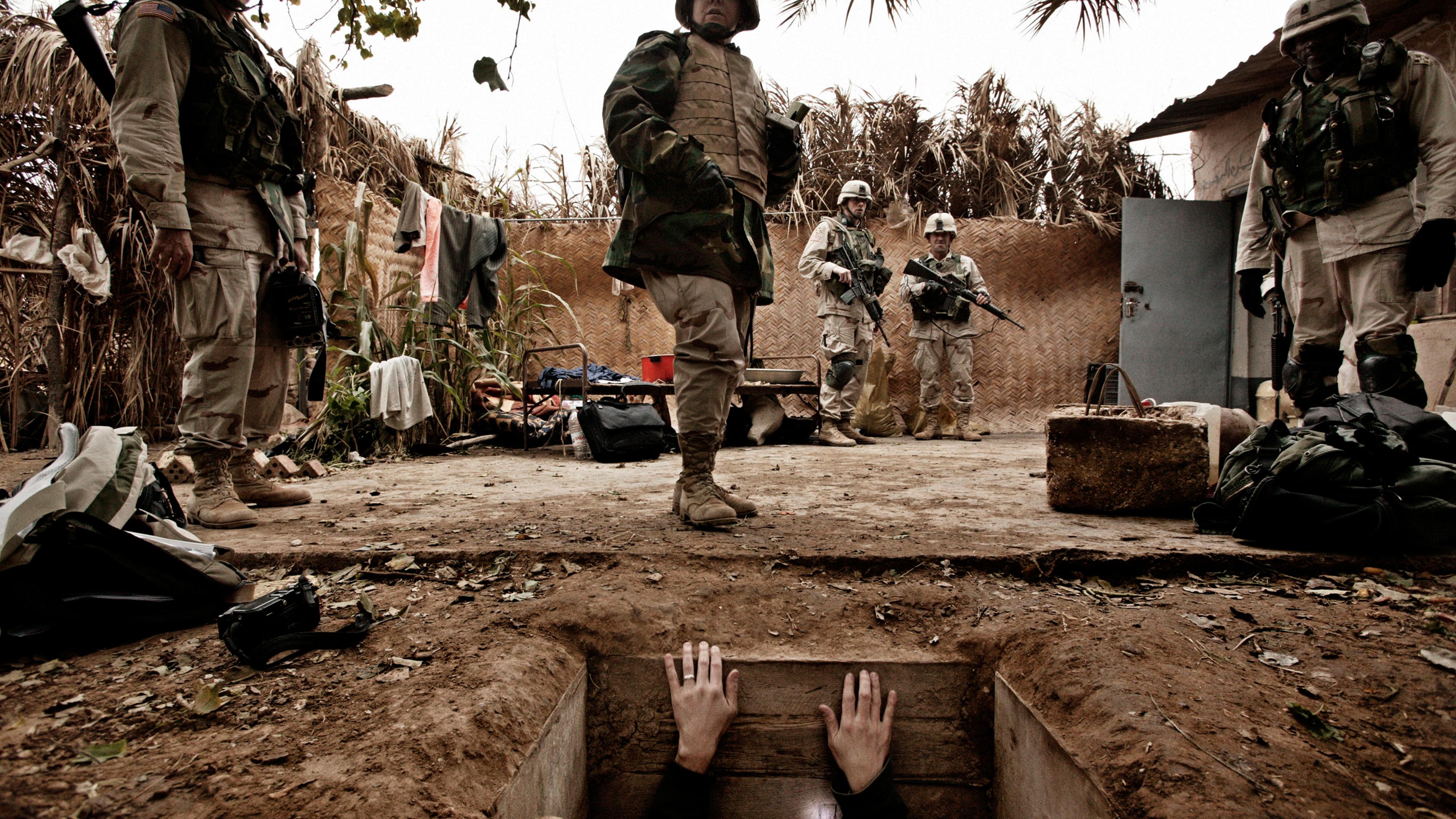 A jounalist climbs out of the hole where toppled dictator Saddam Hussein was captured in Ad Dawr, Iraq, near his hometown of Tikrit, Dec. 15, 2003.